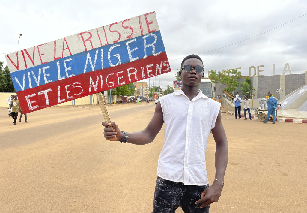A supporter of Niger's ruling junta holds a placard in the colors of the Russian flag reading "Long Live Russia, Long Live Niger and Nigeriens" 