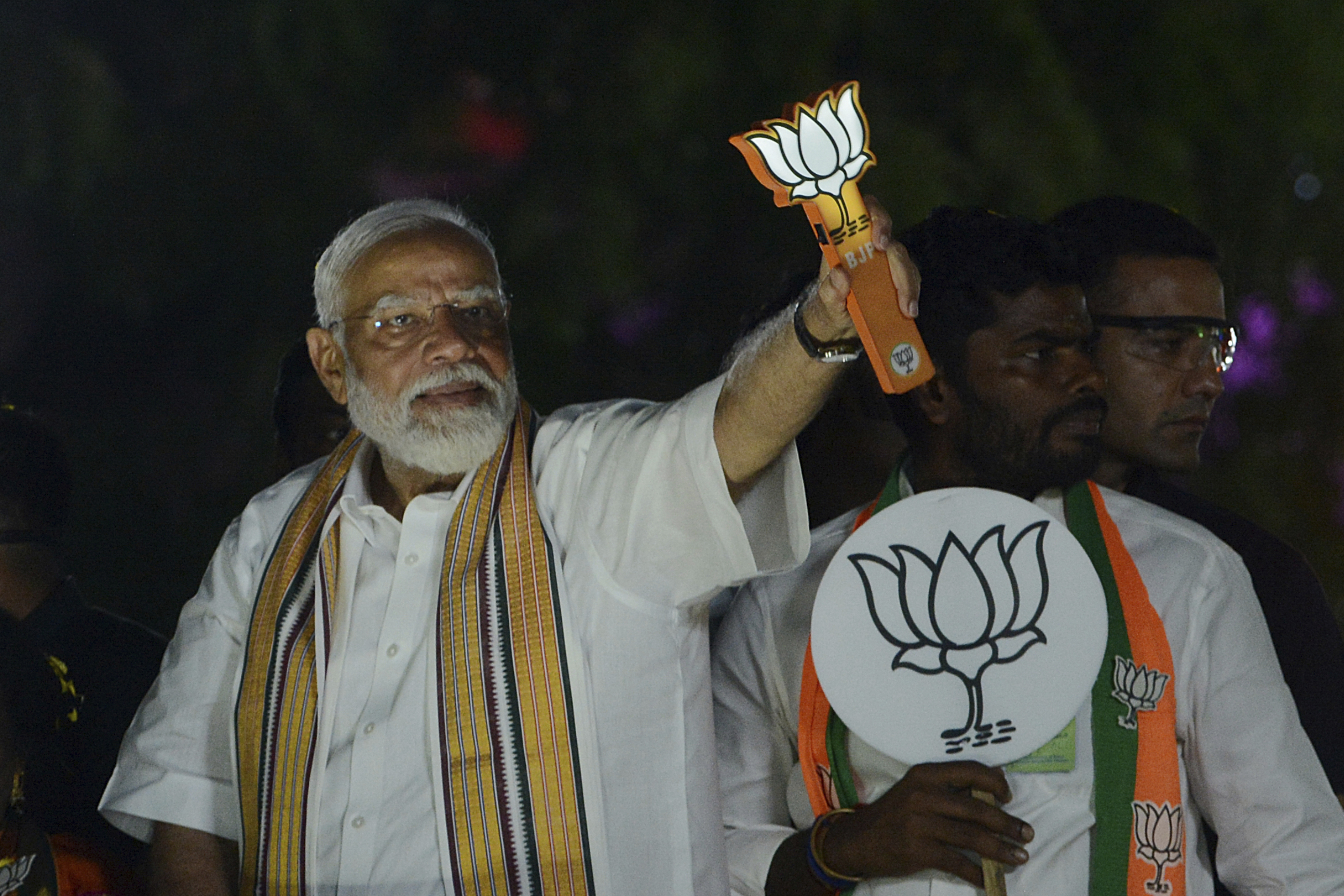 Indian Prime Minister Narendra Modi displays the Bharatiya Janata Party (BJP) symbol, lotus, during a road show while campaigning for national elections, in Chennai, India, Tuesday, April 9, 2024. (AP Photo)