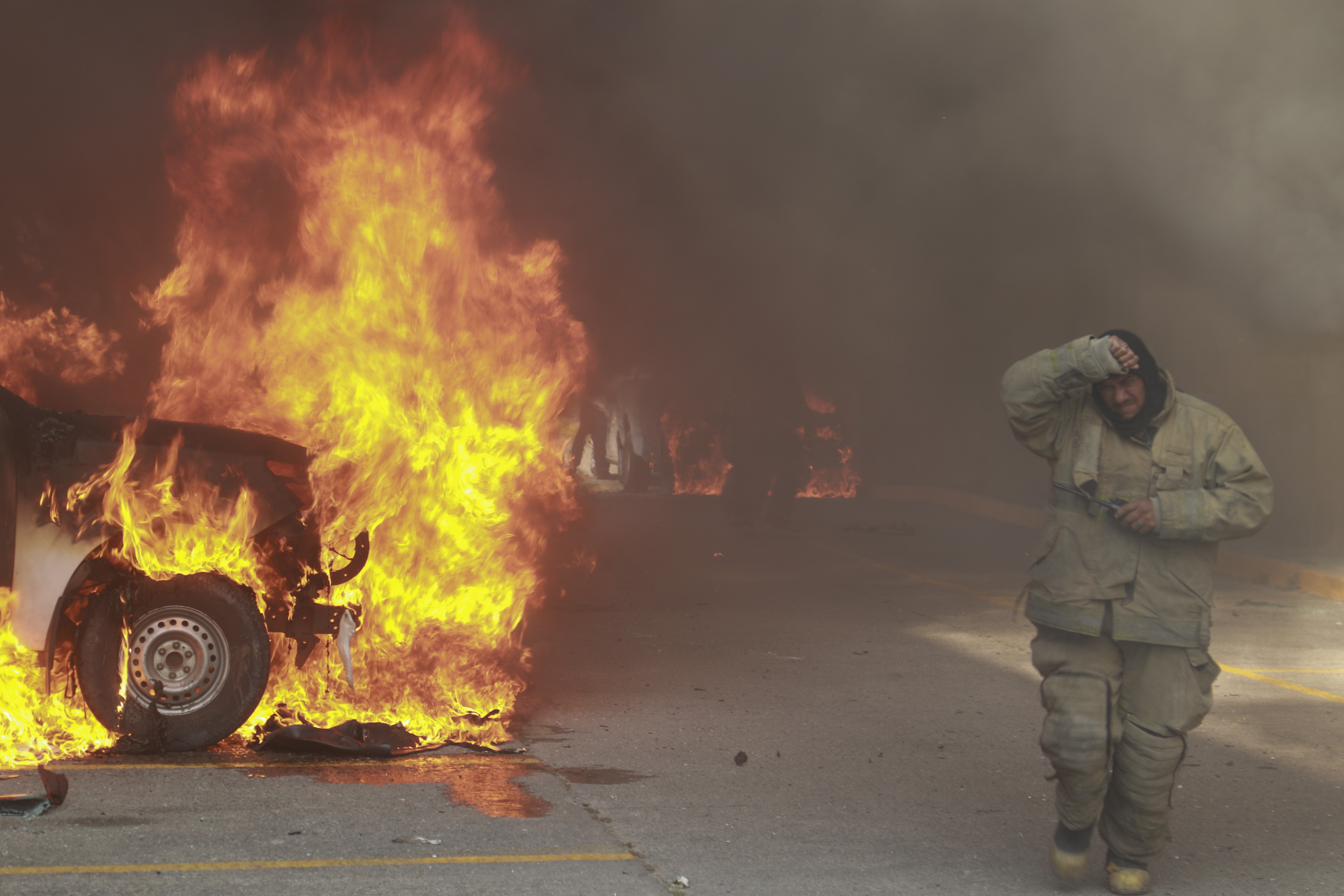 A truck burns after it was set on fire by rural teachers' college students protesting the previous month's shooting of one of their classmates during a confrontation with police, as firefighters work to control the blazes outside the municipal government palace in Chilpancingo, Mexico, April 8