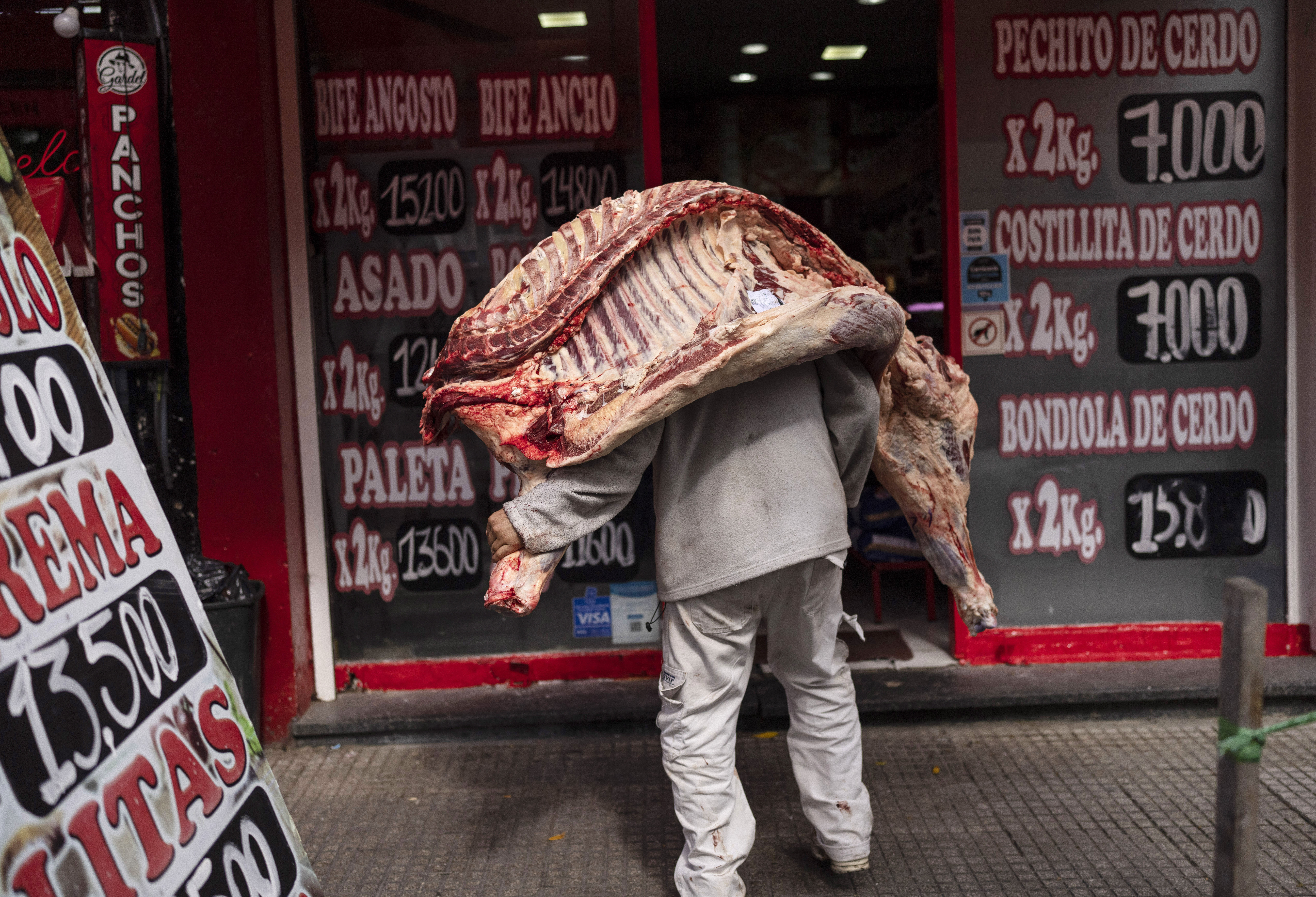 A seller delivers a beef carcass to a butcher shop in Buenos Aires, Argentina, April 10