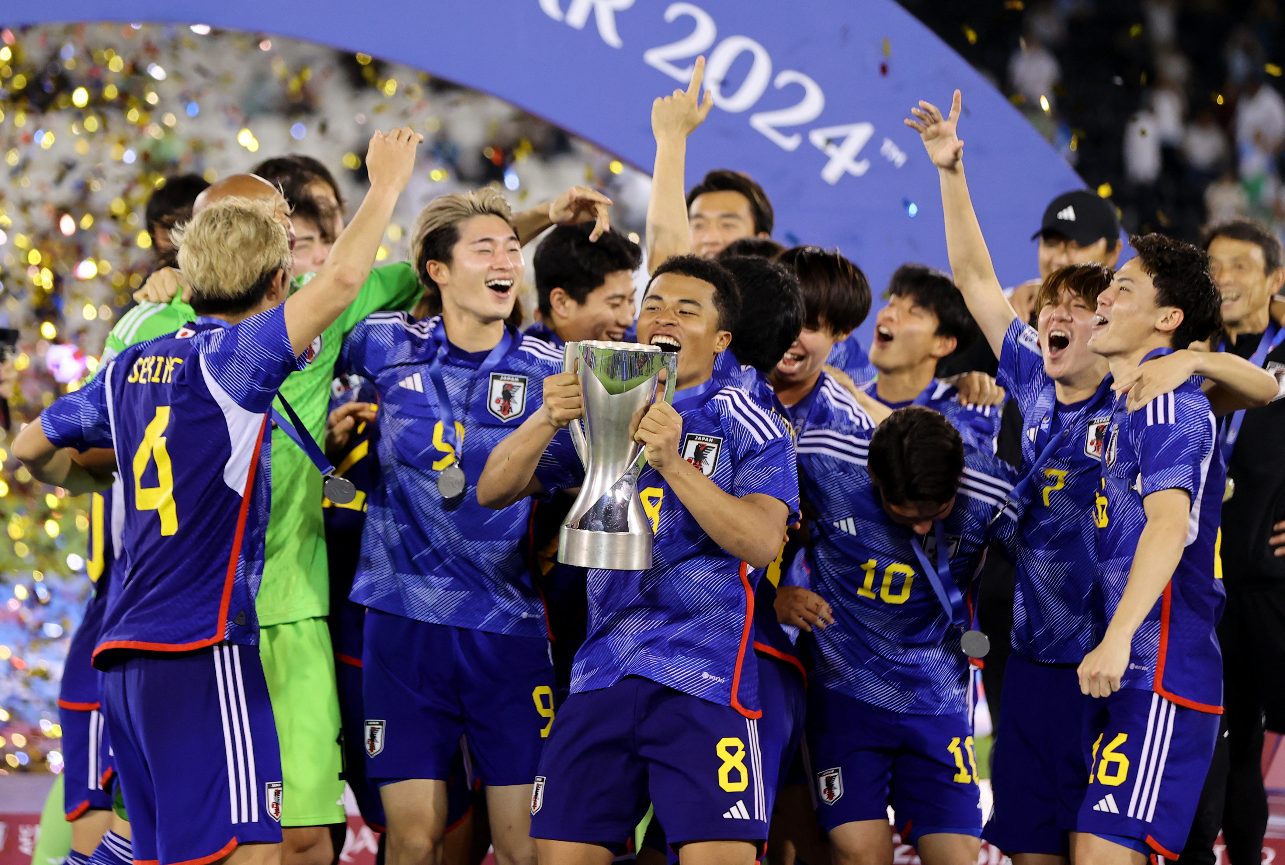 Japan's Joel Fujita celebrates with the trophy and teammates after winning the AFC U-23 Asian Cup final