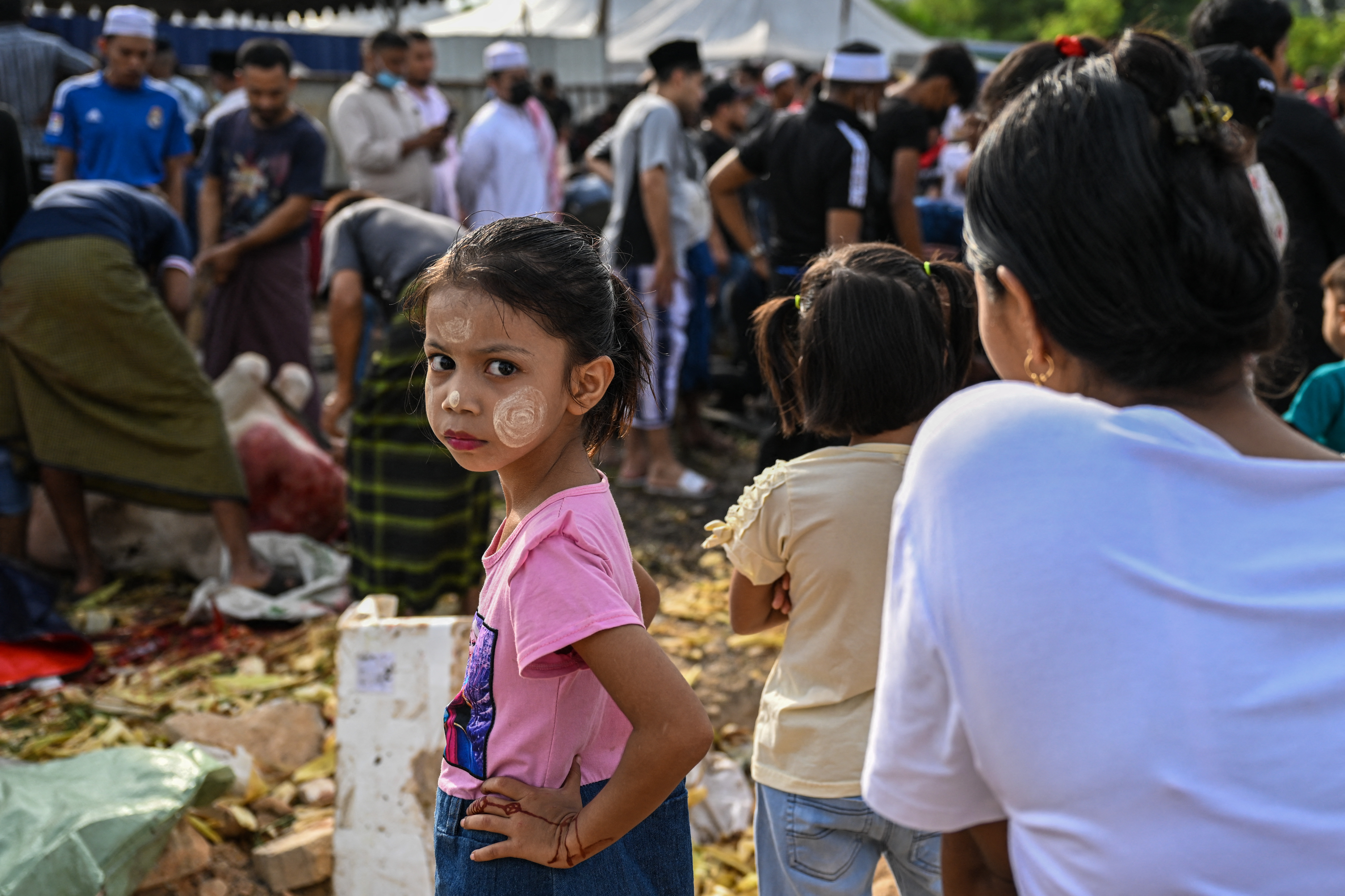 A Rohingya refugee girl from Myanmar at an event with her family in Kuala Lumpur. Her cheeks are smeared with traditional yellow Thanaka paste.