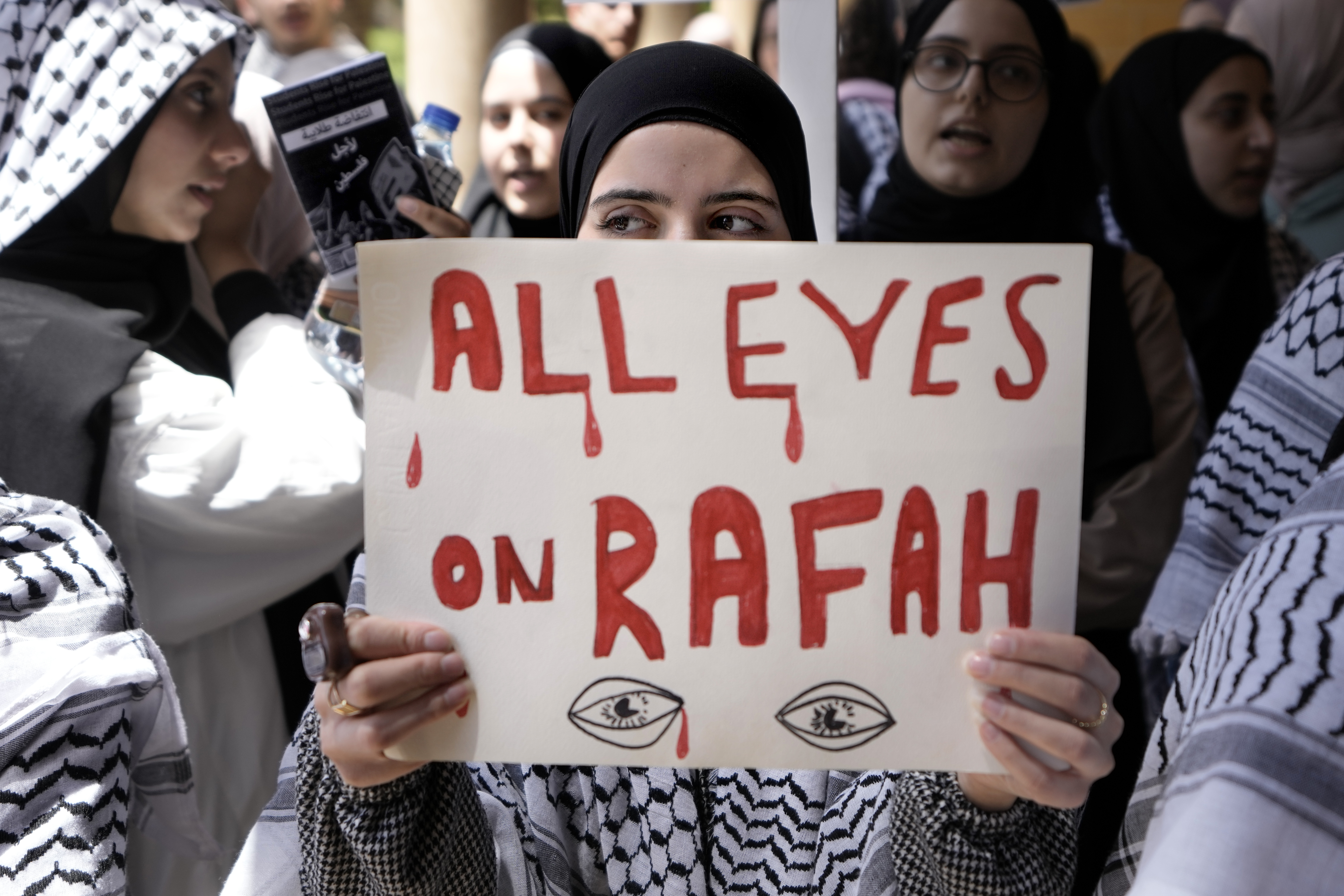 A student holds a placard as she chants slogans during a protest inside the American University of Beirut to show support for Palestinians in the Gaza Strip
