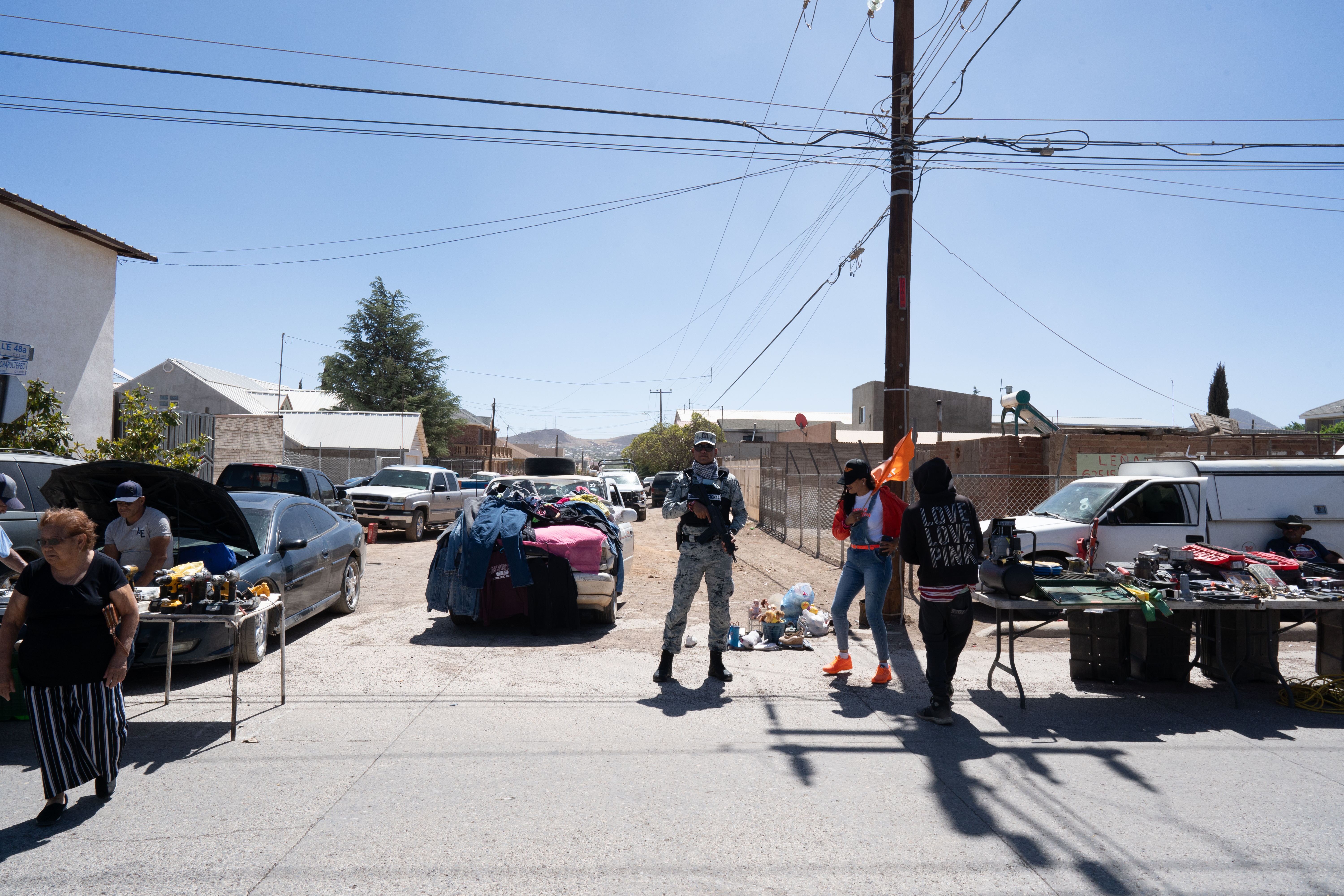 A National Guard agent in fatigues stands in the middle of a road, holding a rifle.