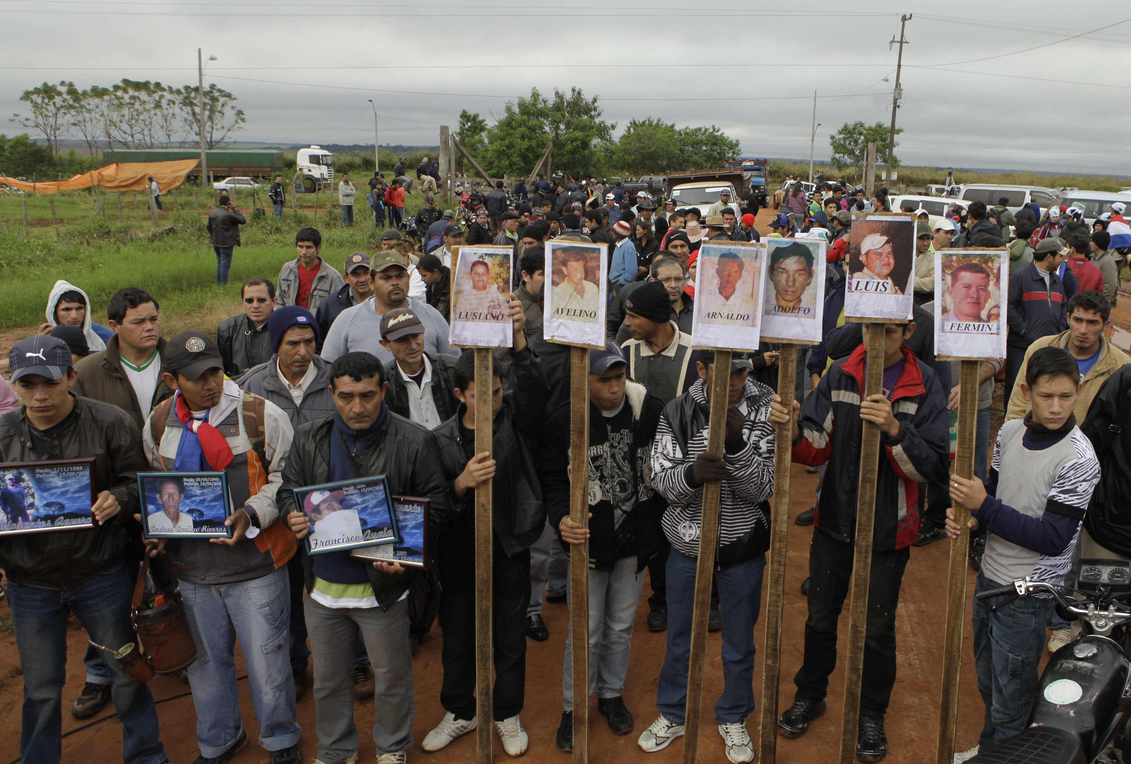 Farmers protest in June 2012 holding pictures of people who died when they were fired upon by police evicting them from a reserve on the outskirts of Curuguaty, Paraguay. The events of that day have come to be known as the Curuguaty massacre [Jorge Saenz/AP Photo]