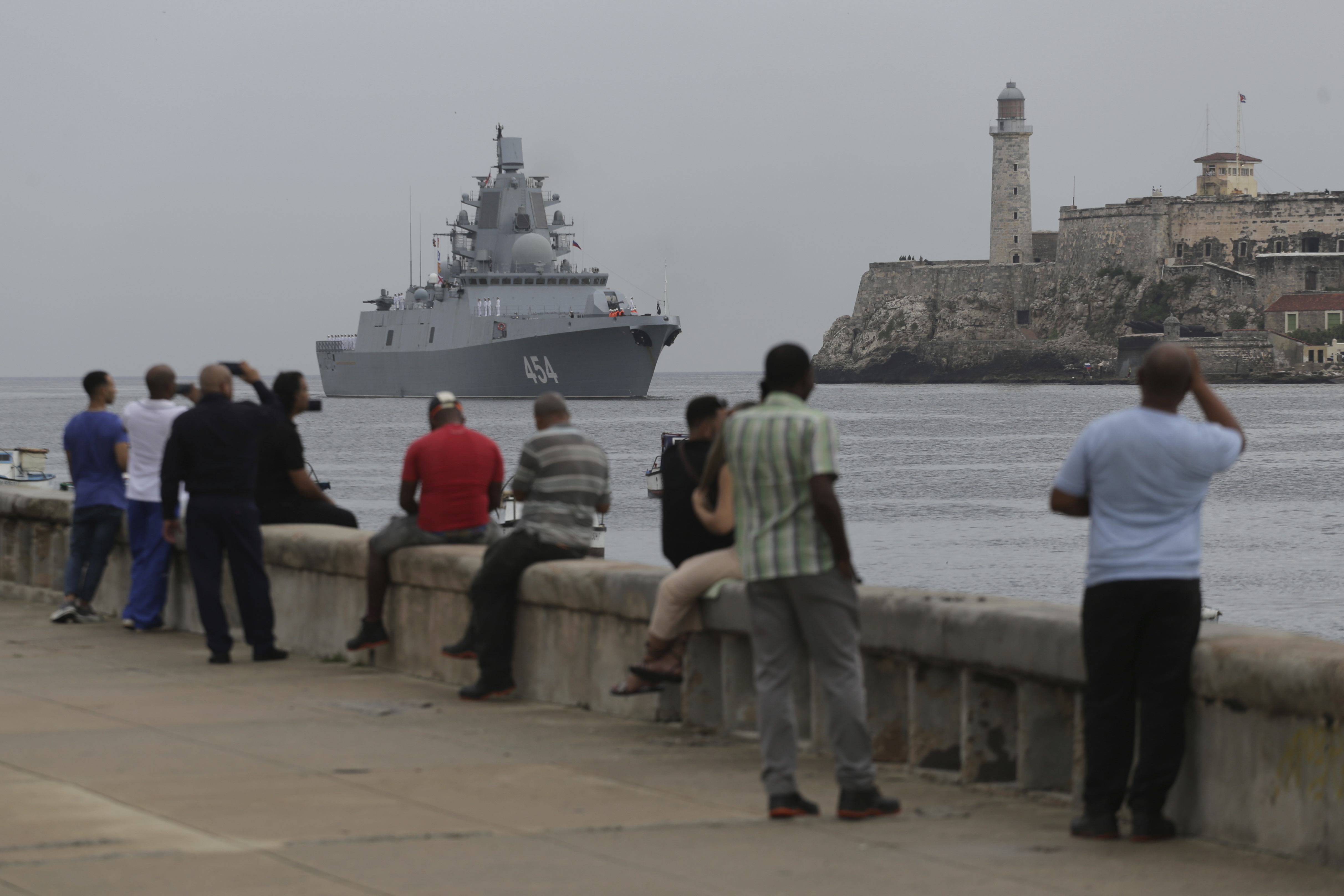 The Admiral Gorskhkov frigate arriving in Havana harbour. People are sitting on the sea wall watching its arrival.