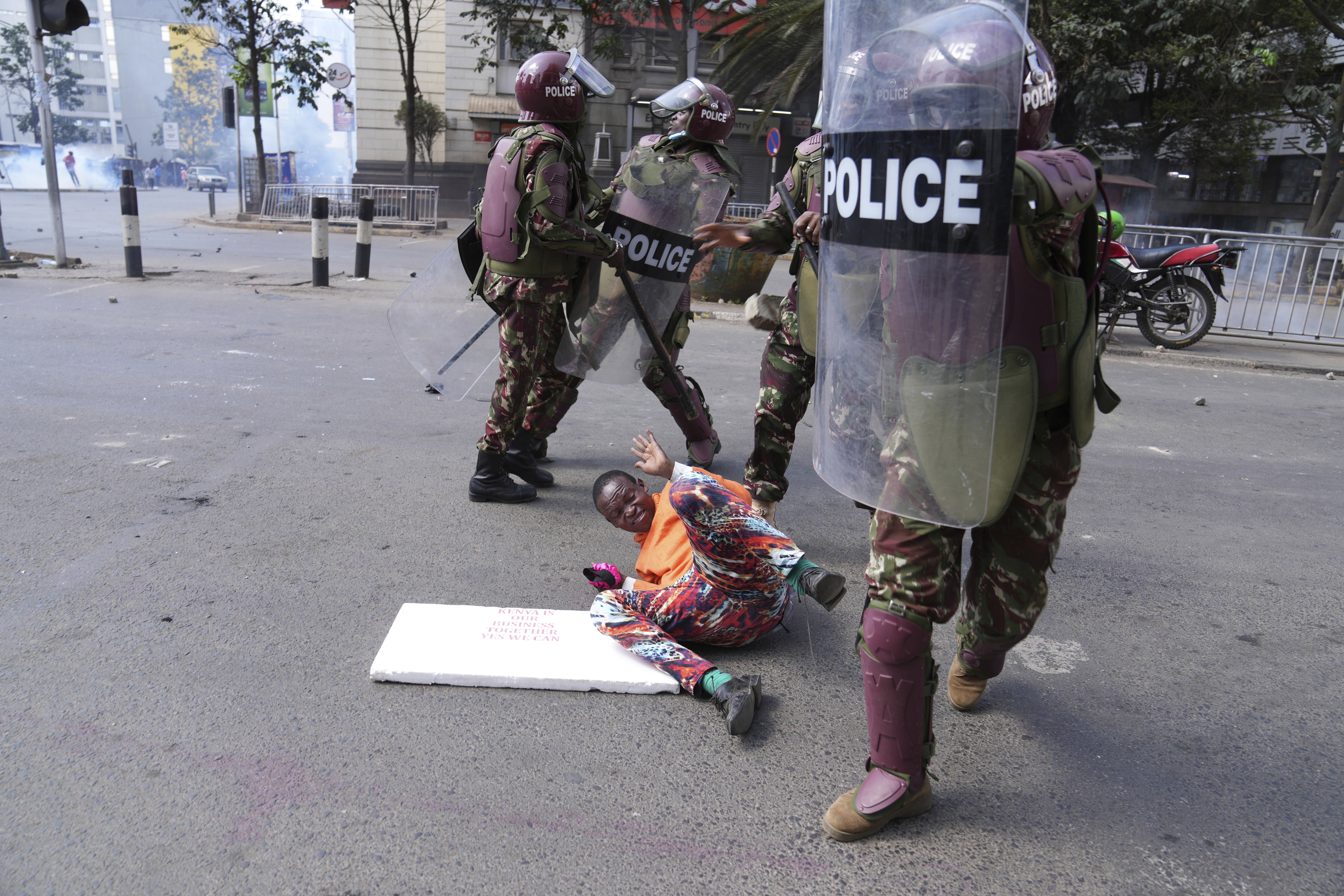 Kenya police beat a protester during a protest over proposed tax hikes in a finance bill in downtown Nairobi, Kenya