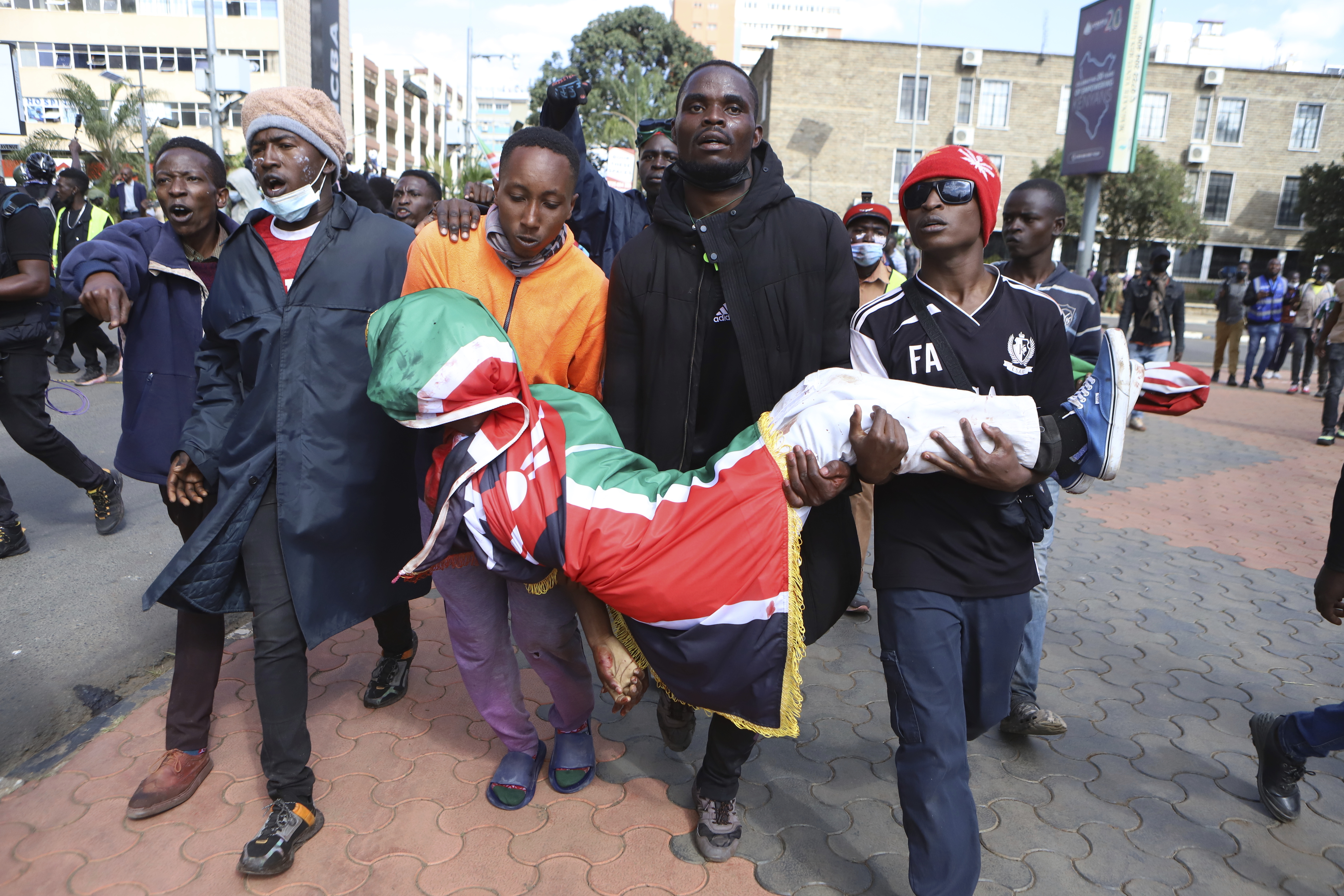 Protesters carry the body of a man who was shot during a protest over proposed tax hikes in a finance bill in downtown Nairobi