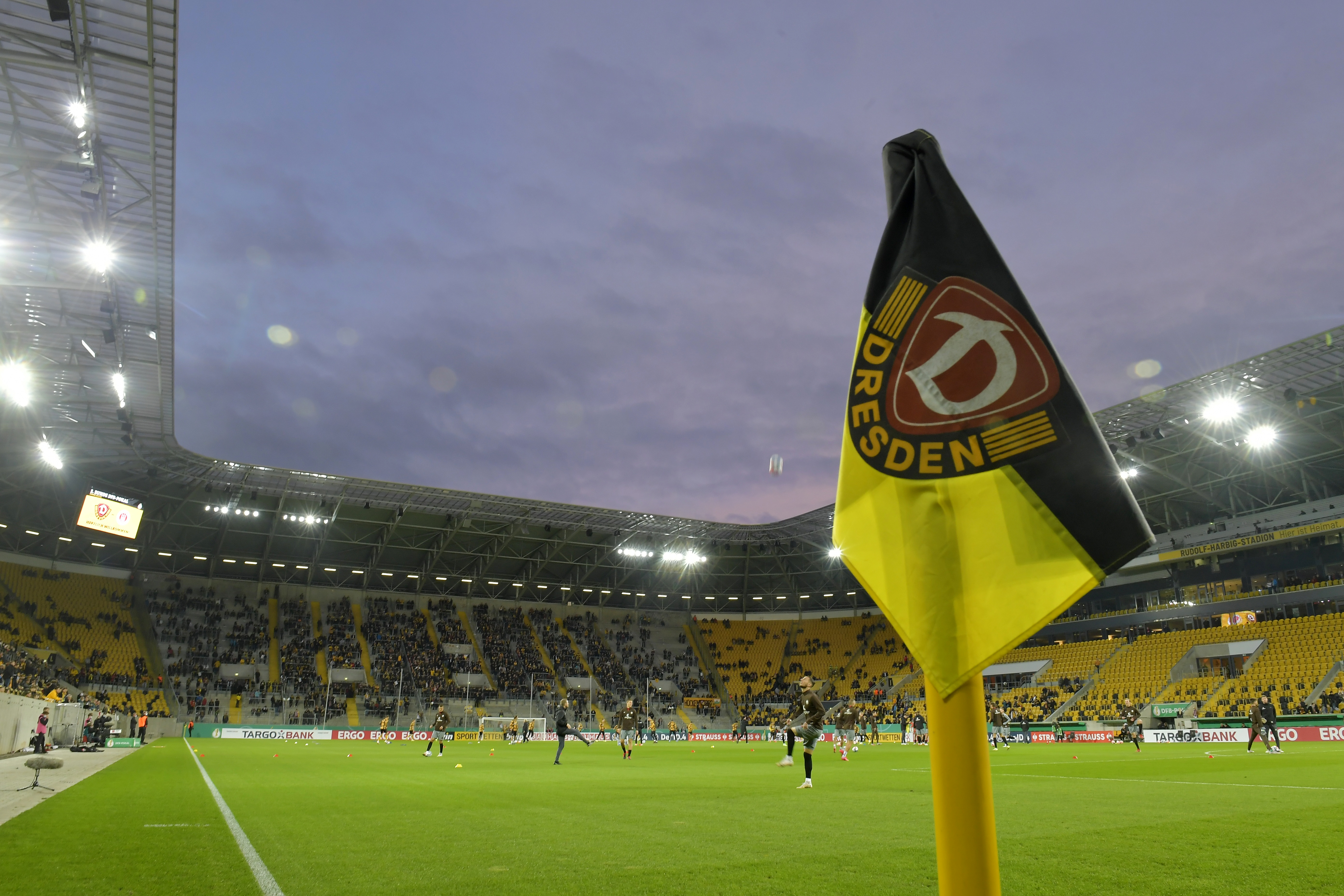 Corner flag pitched in front of football stadium.