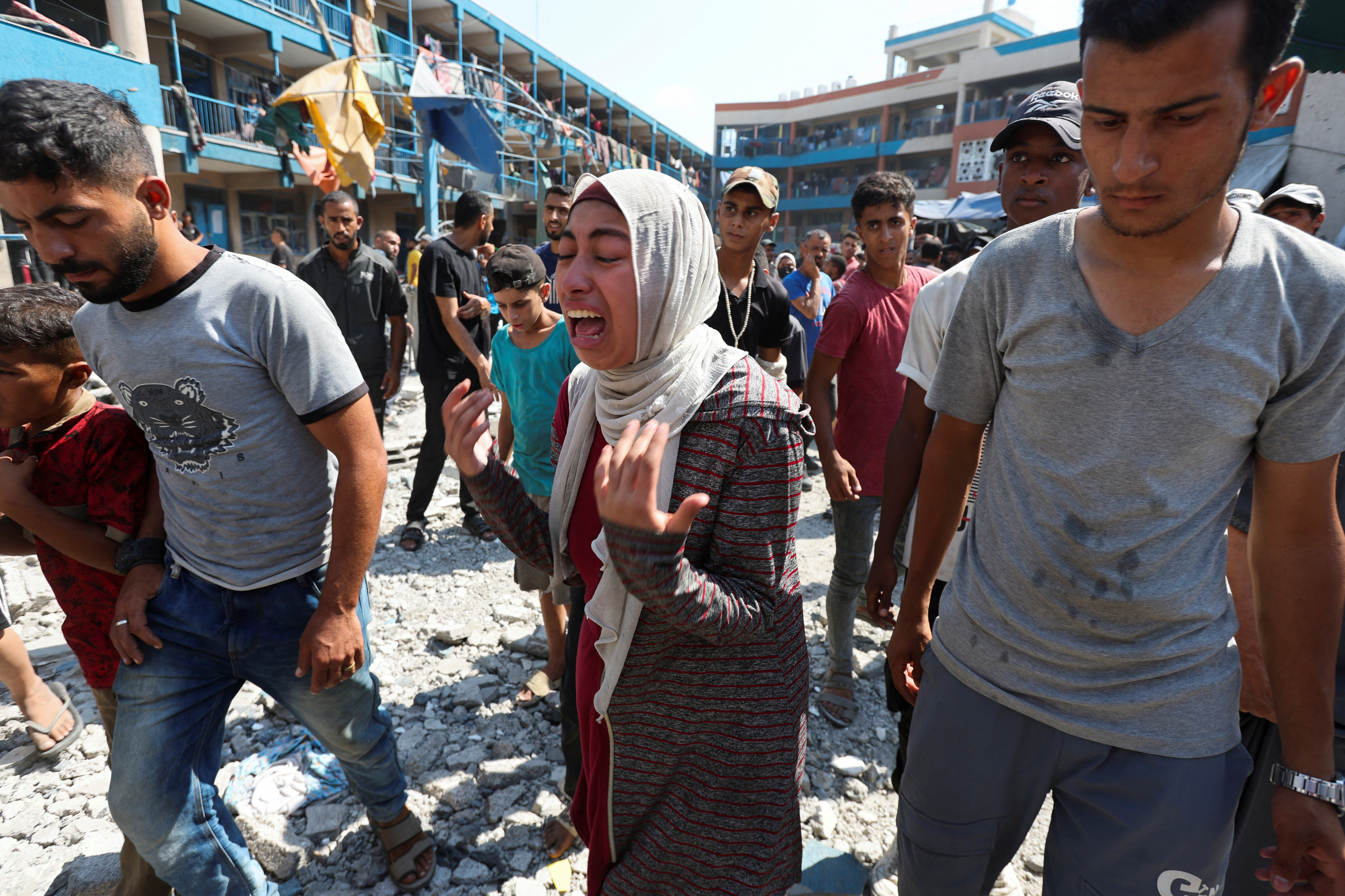 A Palestinian woman reacts at the site of an Israeli air strike on a UN school sheltering displaced people
