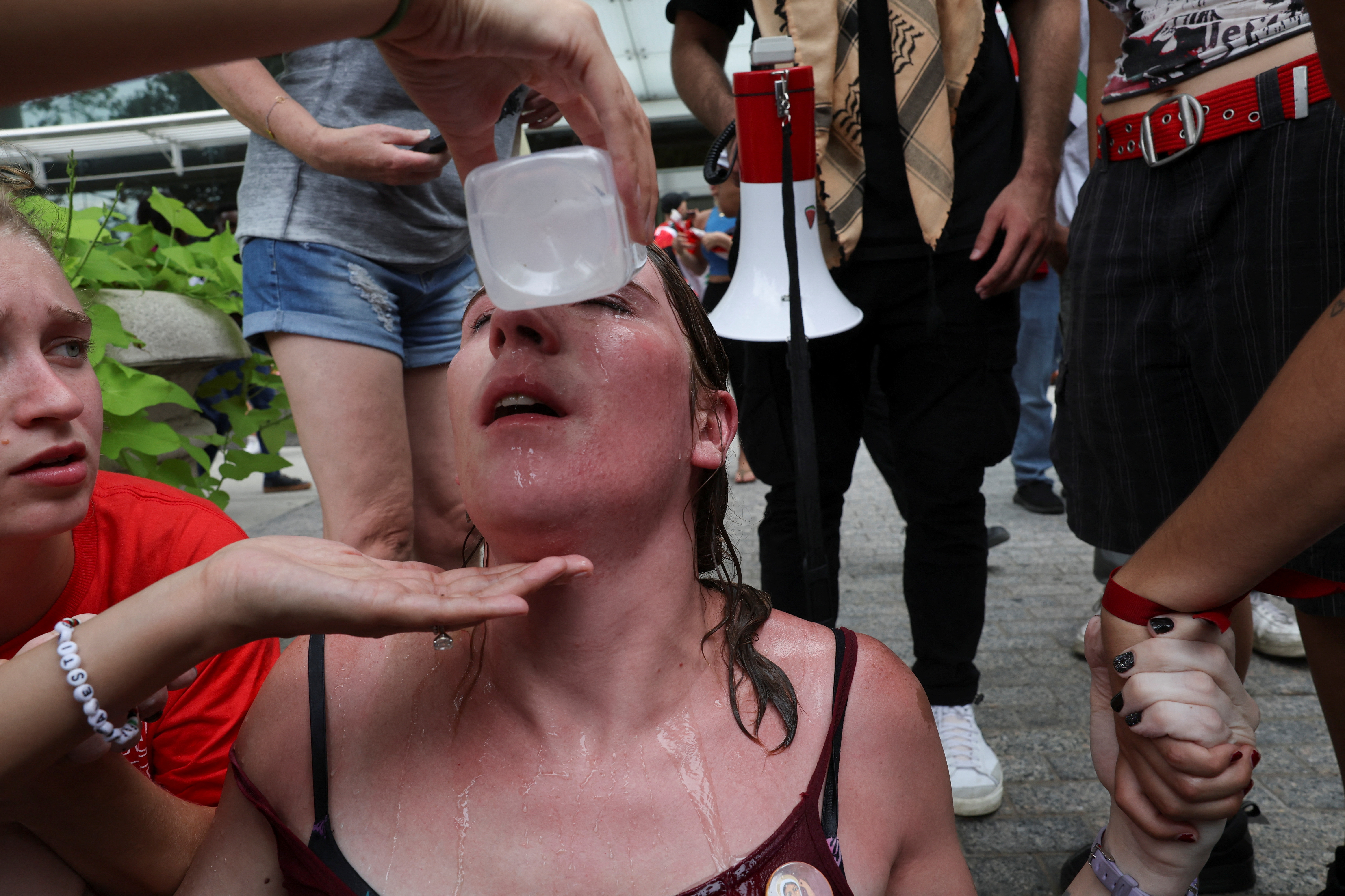 A protester gets her eyes washed out after pepper spray.