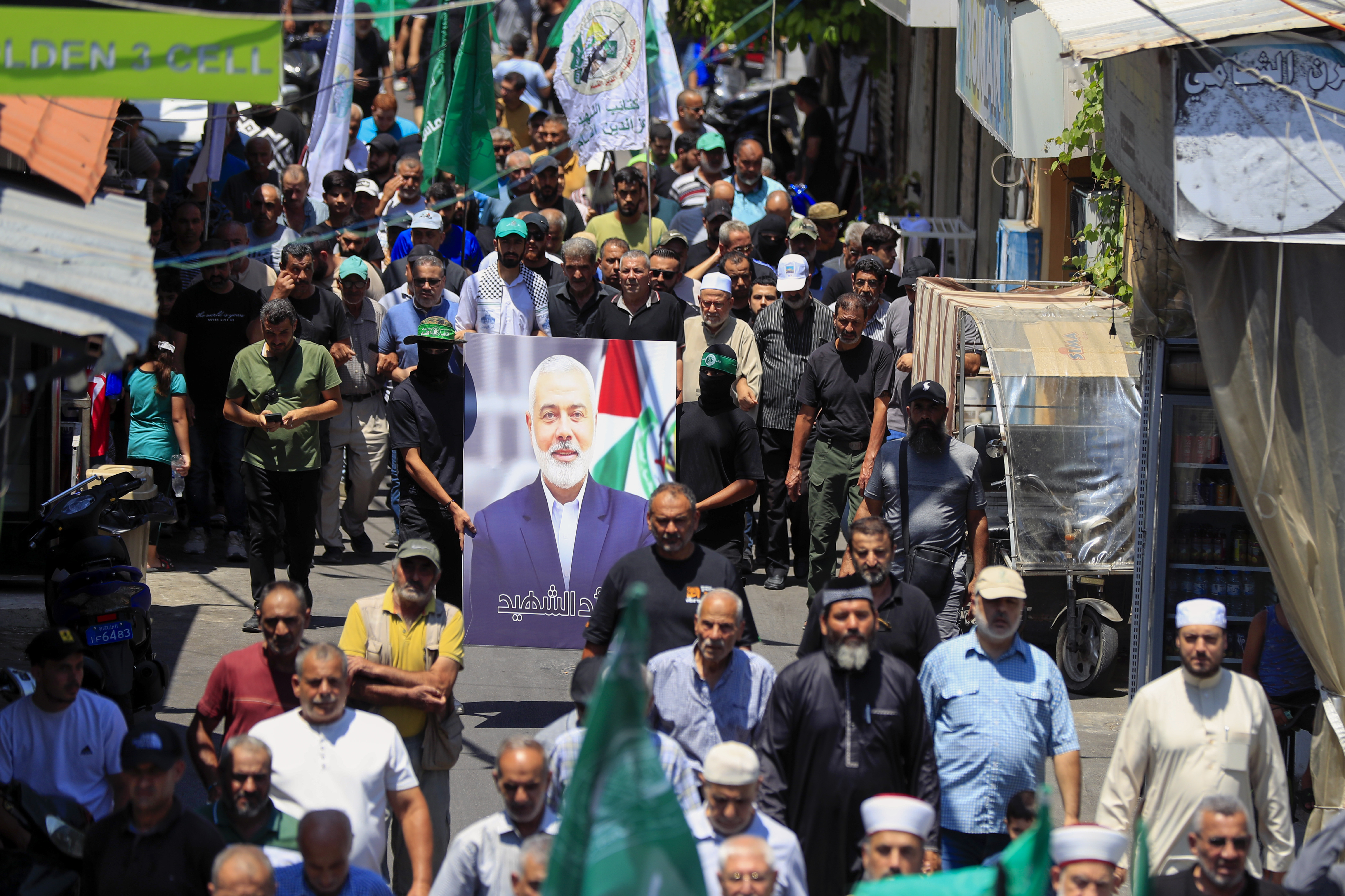 Hamas members hold a portrait of Hamas political chief Ismail Haniyeh during a protest to condemn his killing, at al-Bass Palestinian refugee camp, in the southern port city of Tyre, Lebanon