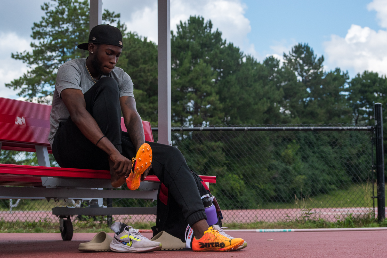 Tamarri Lindo laces up his cleats at a Toronto track