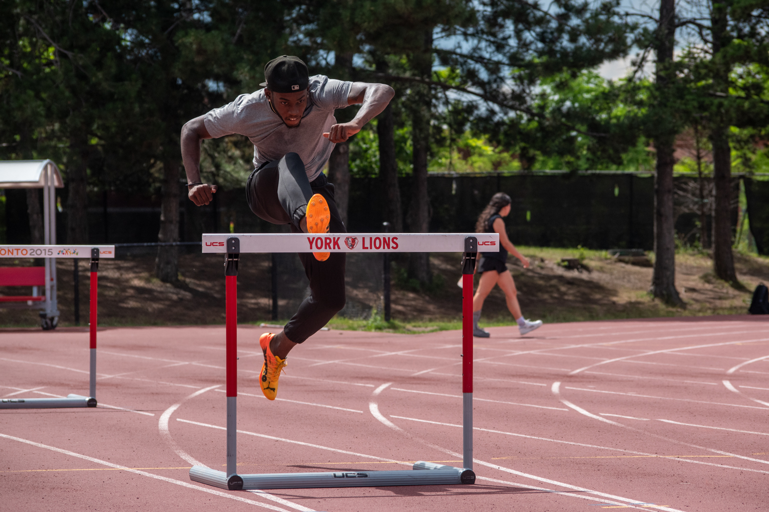 Tamarri Lindo leaps over a hurdle on an outdoor track.
