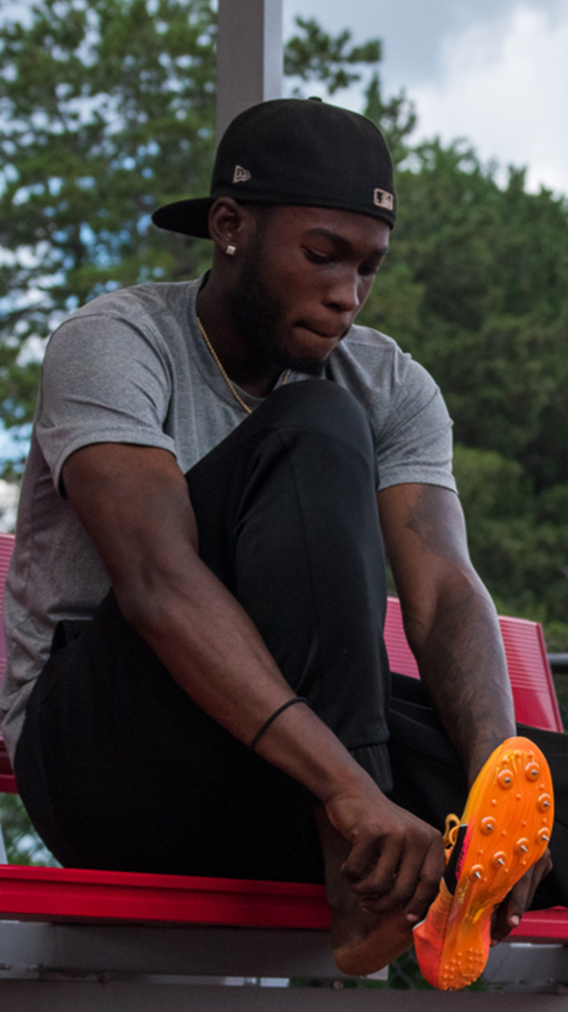 Tamarri Lindo puts on a pair of orange running shoes.