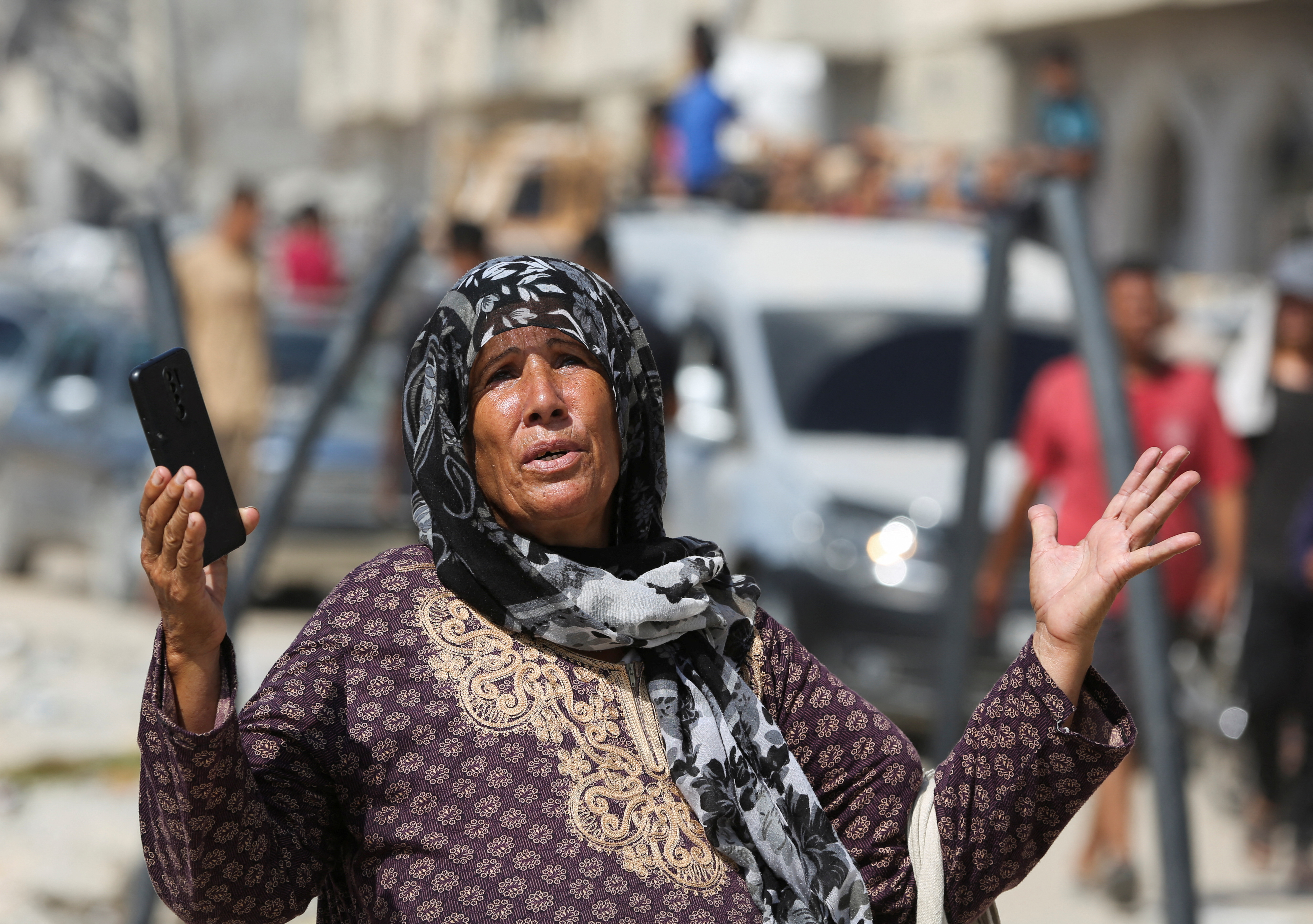 A woman reacts as displaced Palestinians make their way while fleeing Hamad City following an Israeli evacuation order, amid the Israel-Hamas conflict, in Khan Younis in the southern Gaza Strip August 11, 2024. REUTERS/Hatem Khaled
