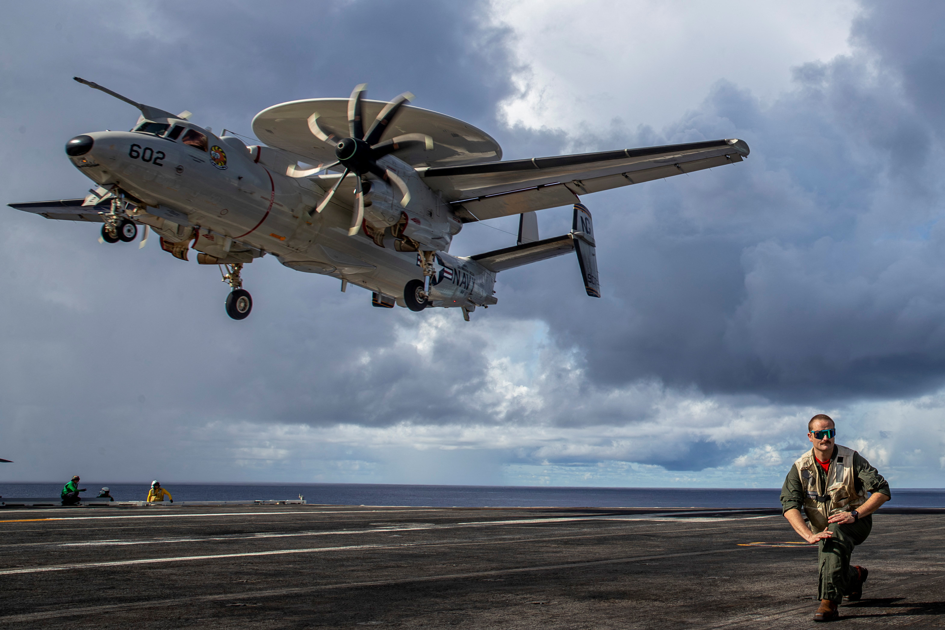 Lt. Craig Darling from Johnstown, N.Y., assigned to Airborne Command &amp; Control Squadron (VAW) 117, stands by as an E-2D Hawkeye prepares to perform a touch and go on the flight deck of the Nimitz-class aircraft carrier USS Abraham Lincoln