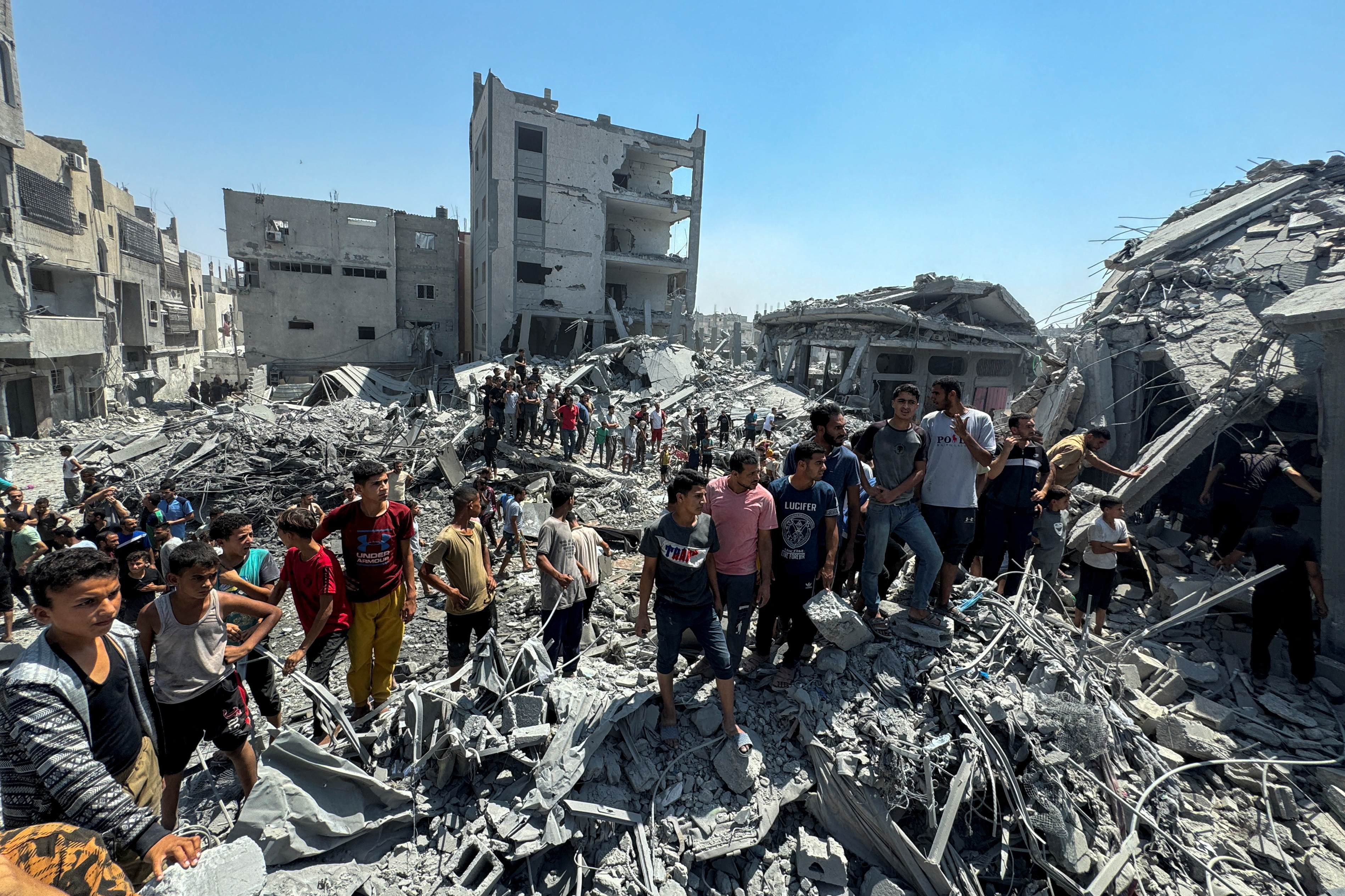 Palestinians gather at the site of an Israeli strike that destroyed several houses, amid Israel-Hamas conflict, in Khan Younis in the southern Gaza Strip August 27, 2024. [Mohammed Salem/Reuters]