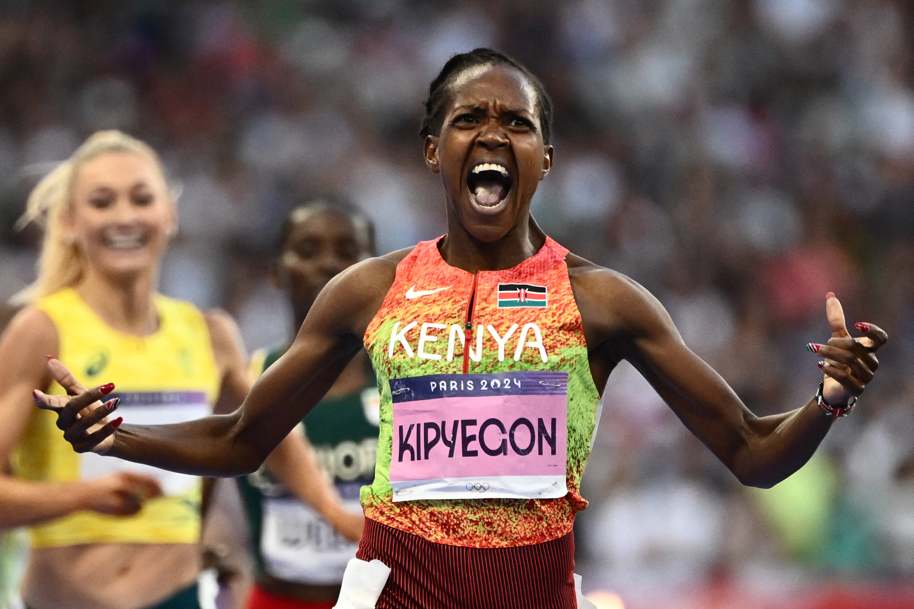 Kenya's Faith Kipyegon reacts as she crosses the finish line in the women's 1500m final of the athletics event at the Paris 2024 Olympic Games at Stade de France [Jewel Samad/AFP]