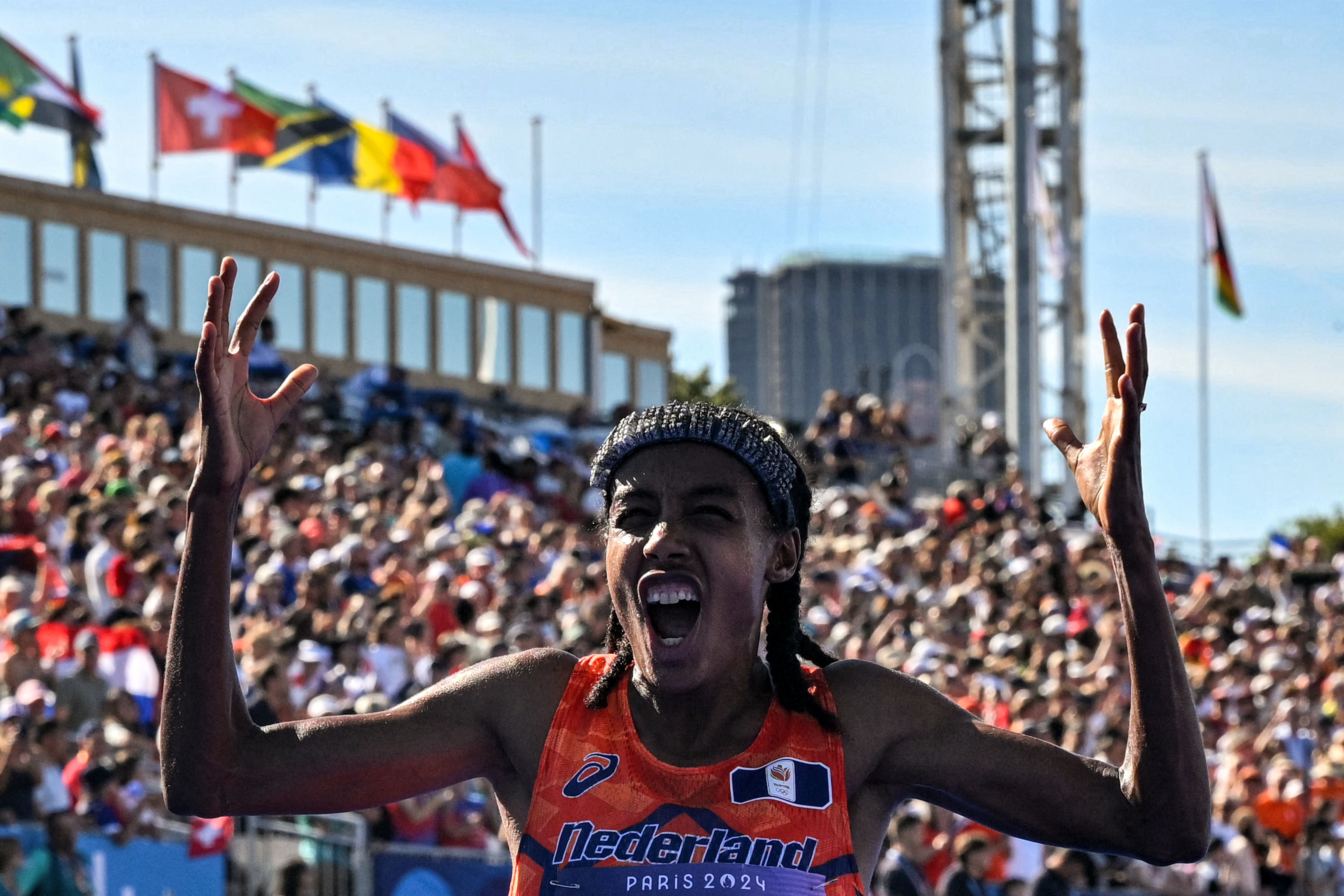 Netherlands' gold medallist Sifan Hassan celebrates crossing the finish in first place in the women's marathon of the athletics event at the Paris 2024 Olympic Games at The Invalides in Paris on August 11, 2024. (Photo by Andrej ISAKOVIC / AFP)