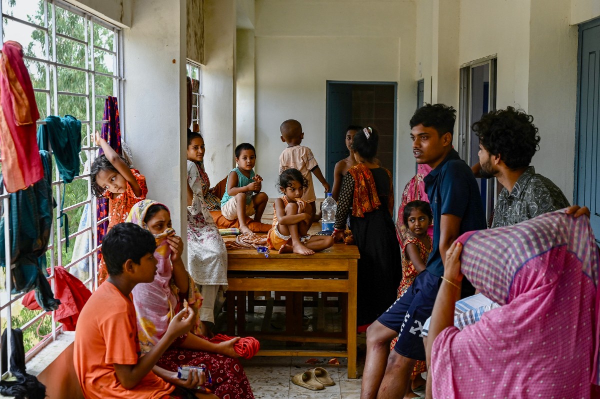 Flood-affected residents take temporary shelter at a school in Feni