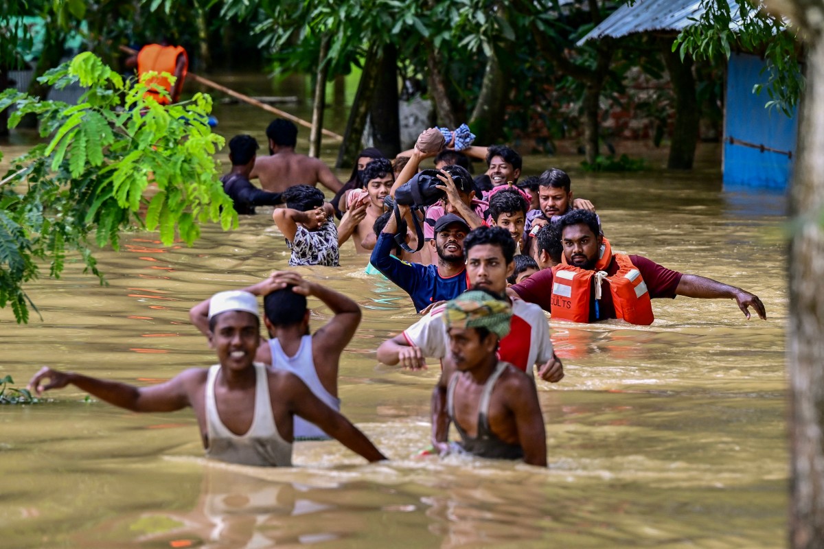 People wade through flood waters in Feni, in south-eastern Bangladesh