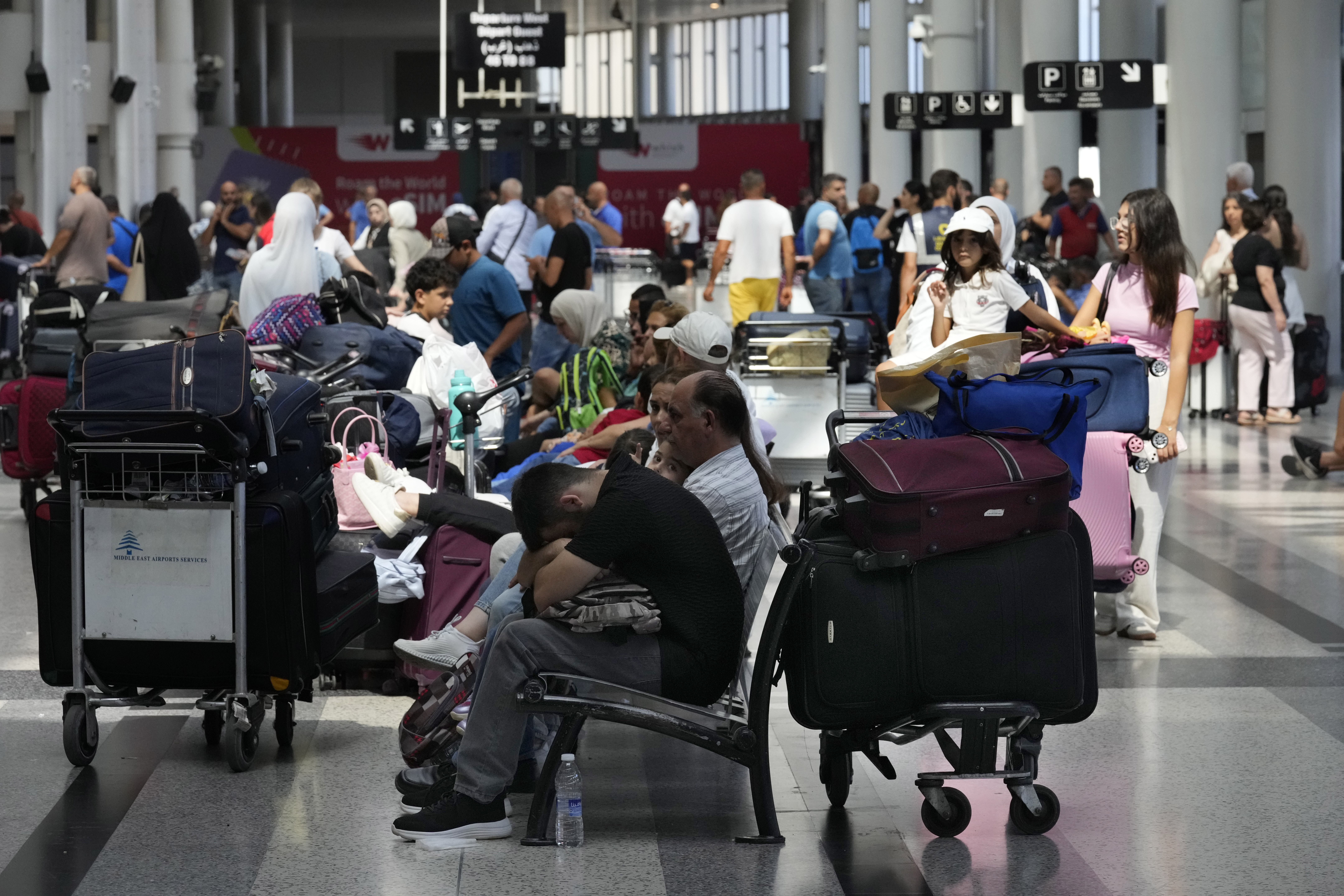 Passengers whose flights were cancelled, wait at the departure terminal of Rafik Hariri International Airport