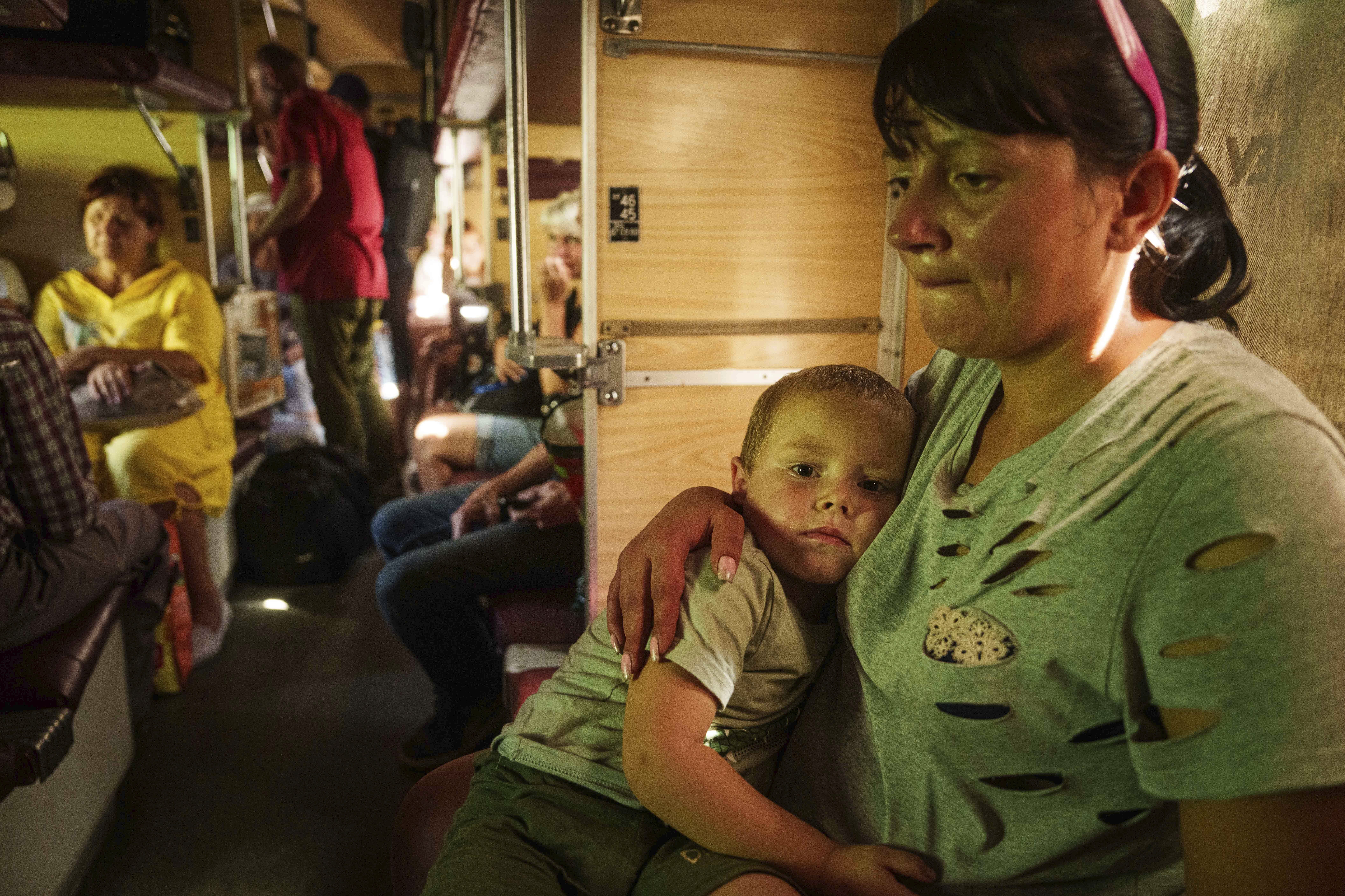 Alla hugs her son Ivan sitting in evacuation train in Pokrovsk, Donetsk region, Ukraine, Monday, August 19, 2024. Due to the advance of Russian troops to the west towards Myrograd, Alla and her son Ivan were forced to evacuate as volunteers. Intensive shelling forced people to leave homes. (AP Photo/Evgeniy Maloletka)