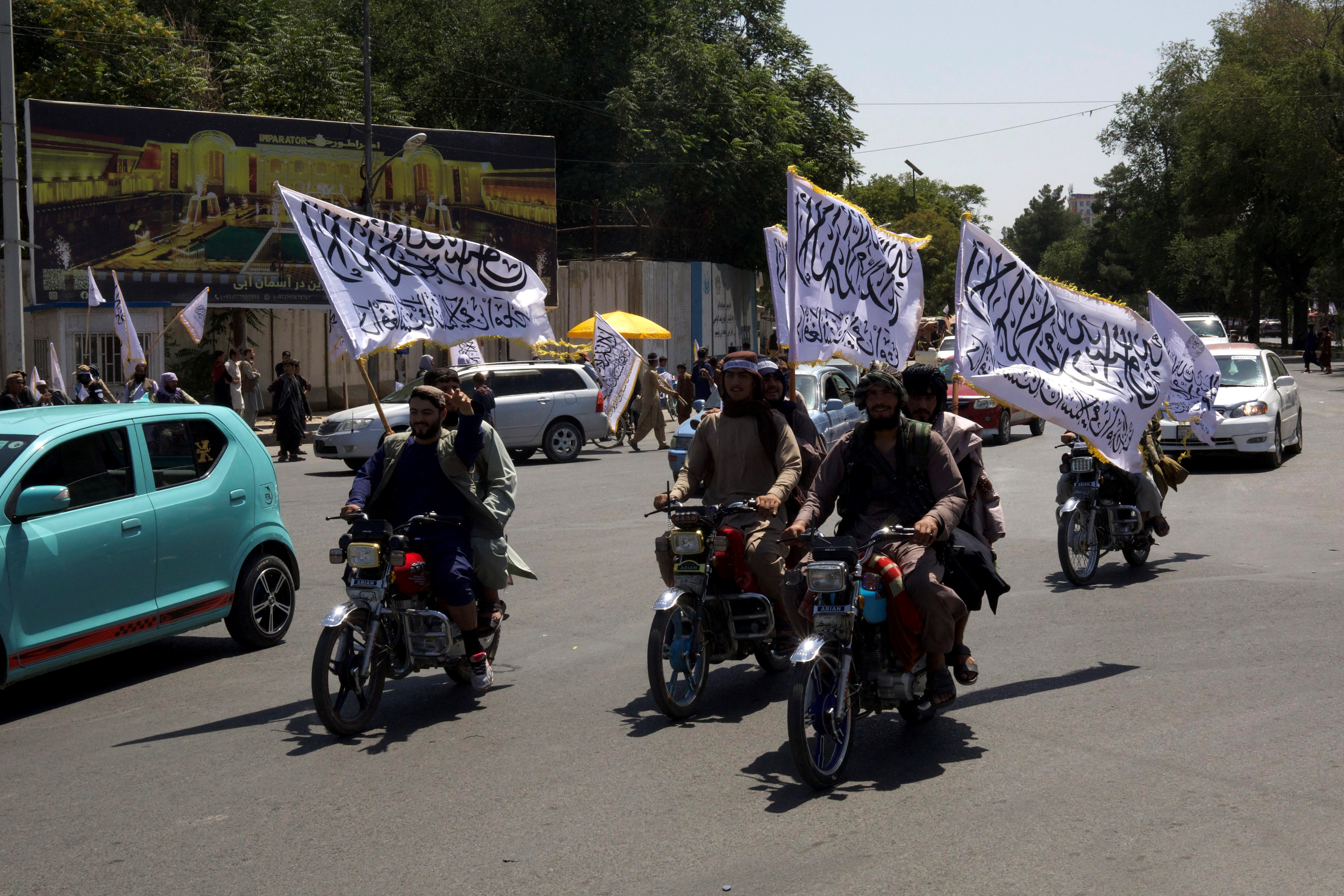 Members of the Taliban carrying flags ride motorbikes as they participate in a rally to mark the third anniversary of the fall of Kabul, in Kabul, Afghanistan, August 14, 2024. REUTERS/Sayed Hassib