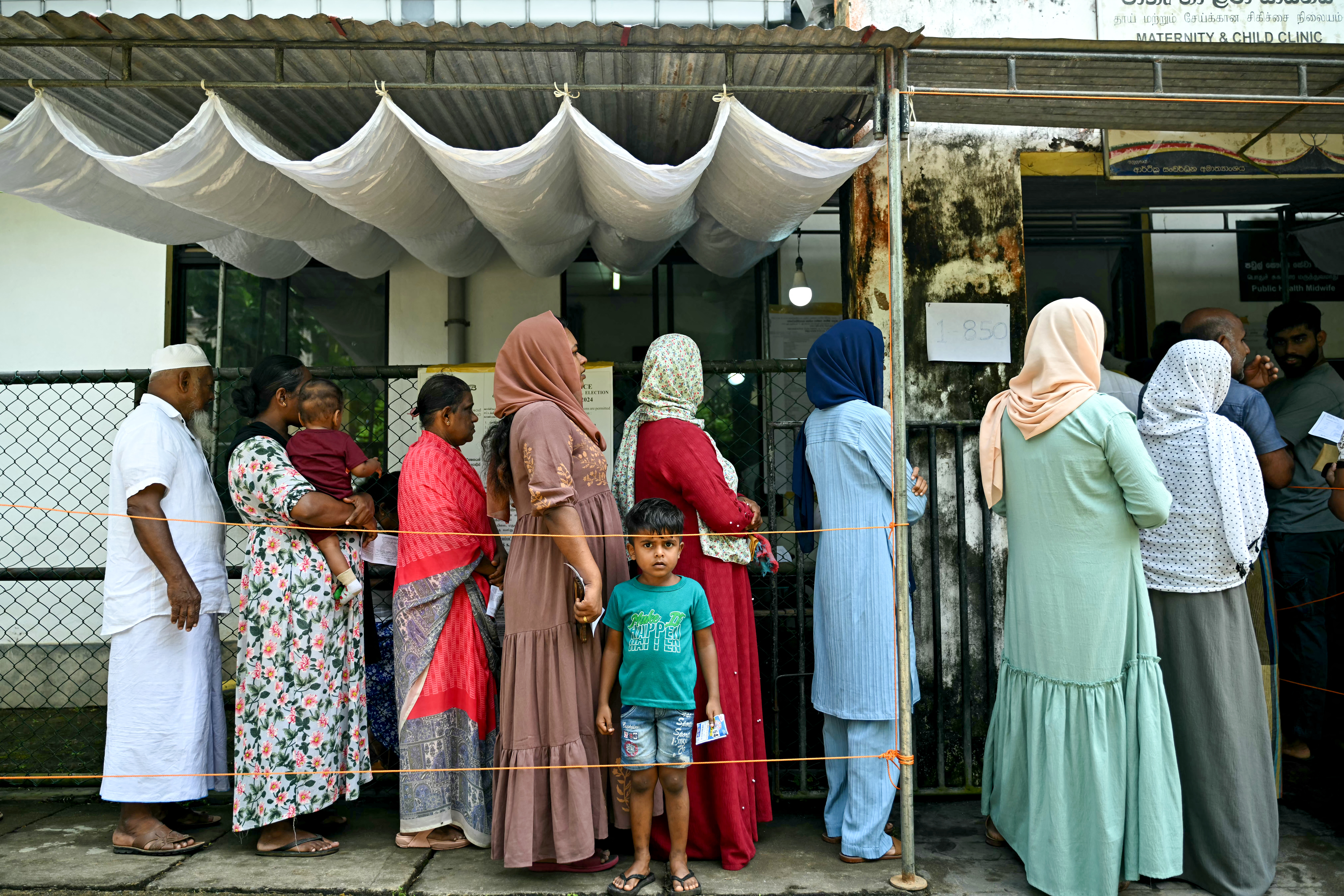 People wait in a queue to cast their ballots at a polling station during voting in Sri Lanka's presidential election in Galle on September 21, 2024. [IDREES MOHAMMED / AFP]
