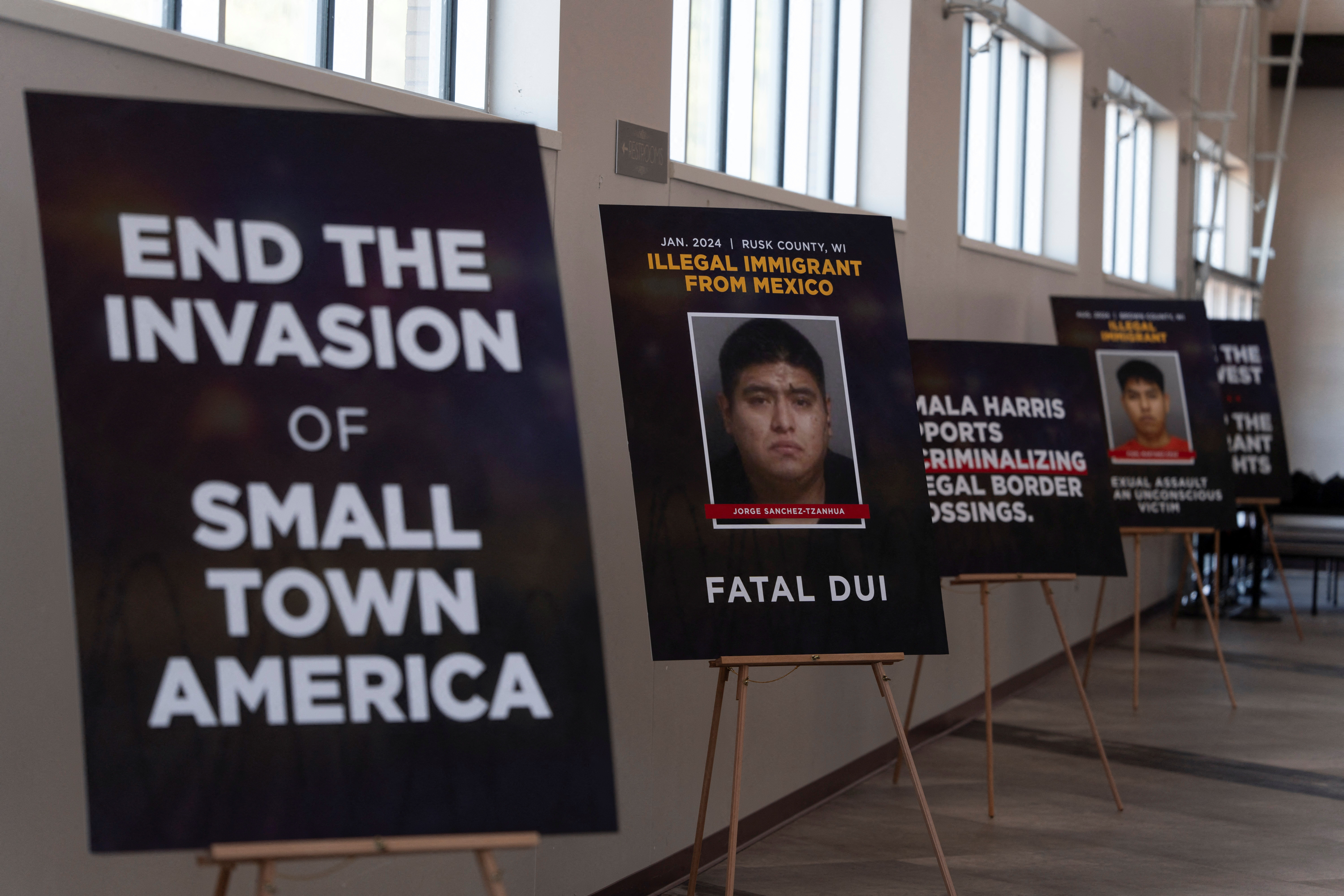 A series of easels shows anti-immigration posters, including one that reads: "End the invasion of small town America."