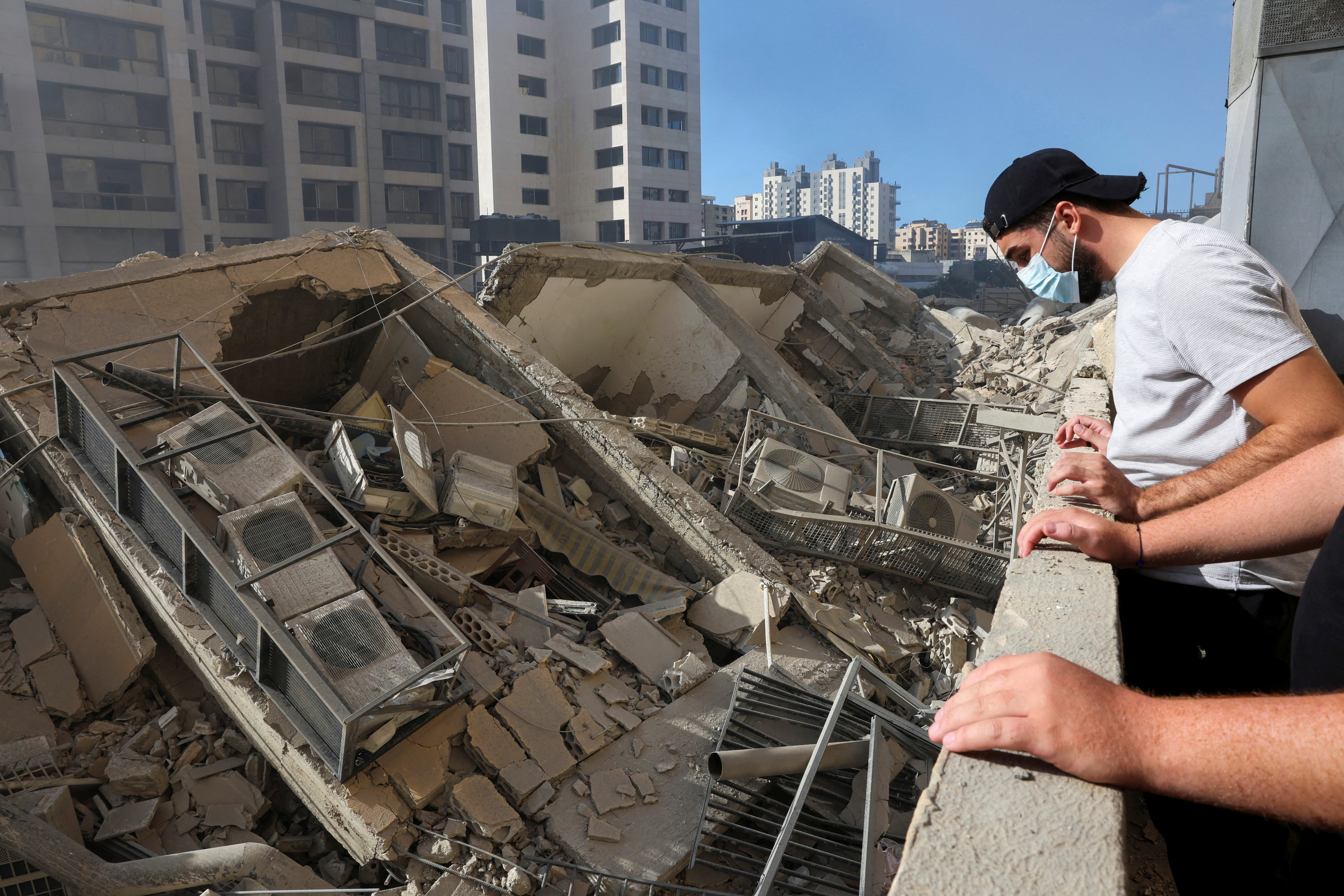 People look at the damage in the aftermath of Israeli strikes in Chiyah