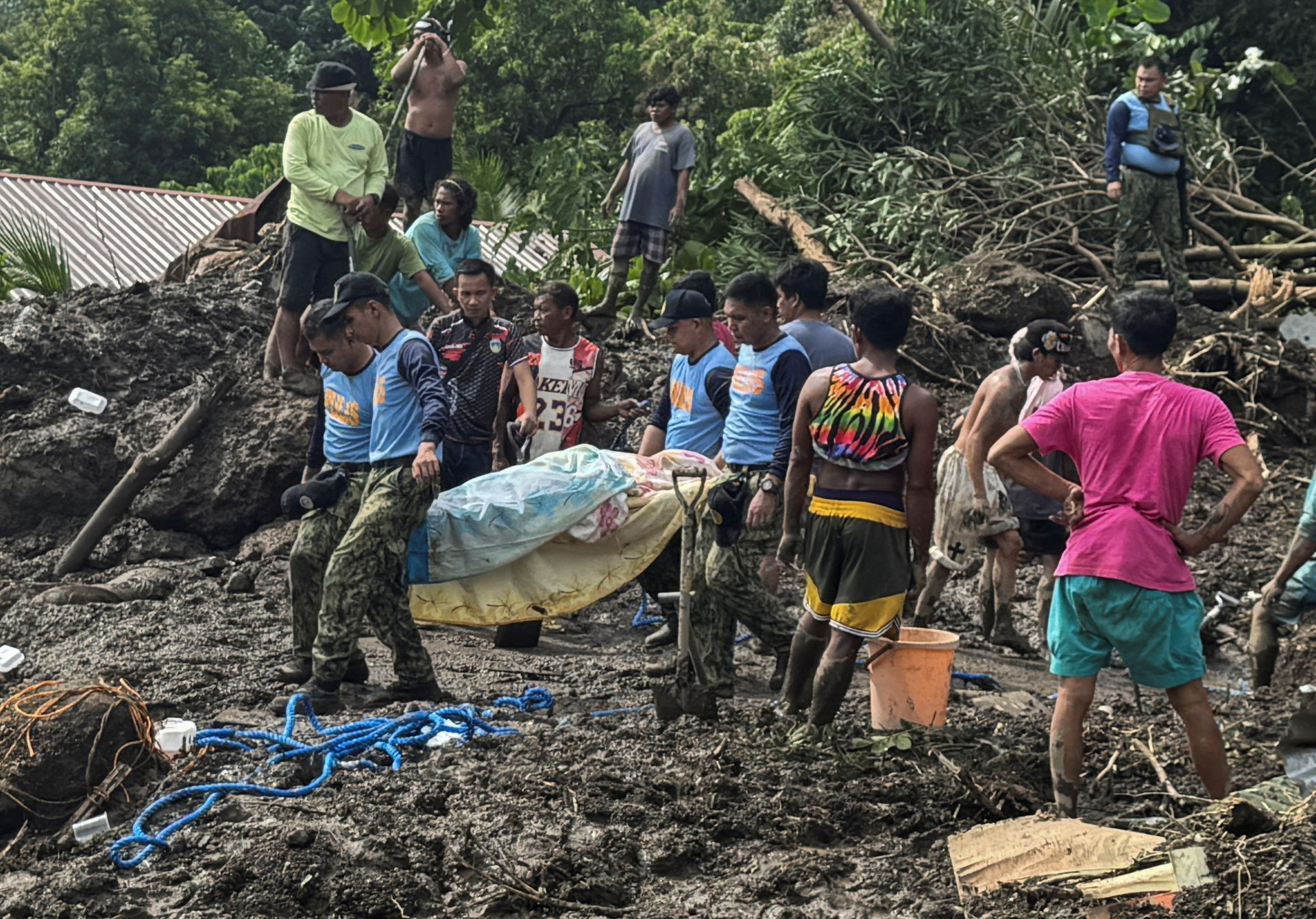 Rescue personnel and residents carrying casualties of a landslide in Batangas province, Philippines