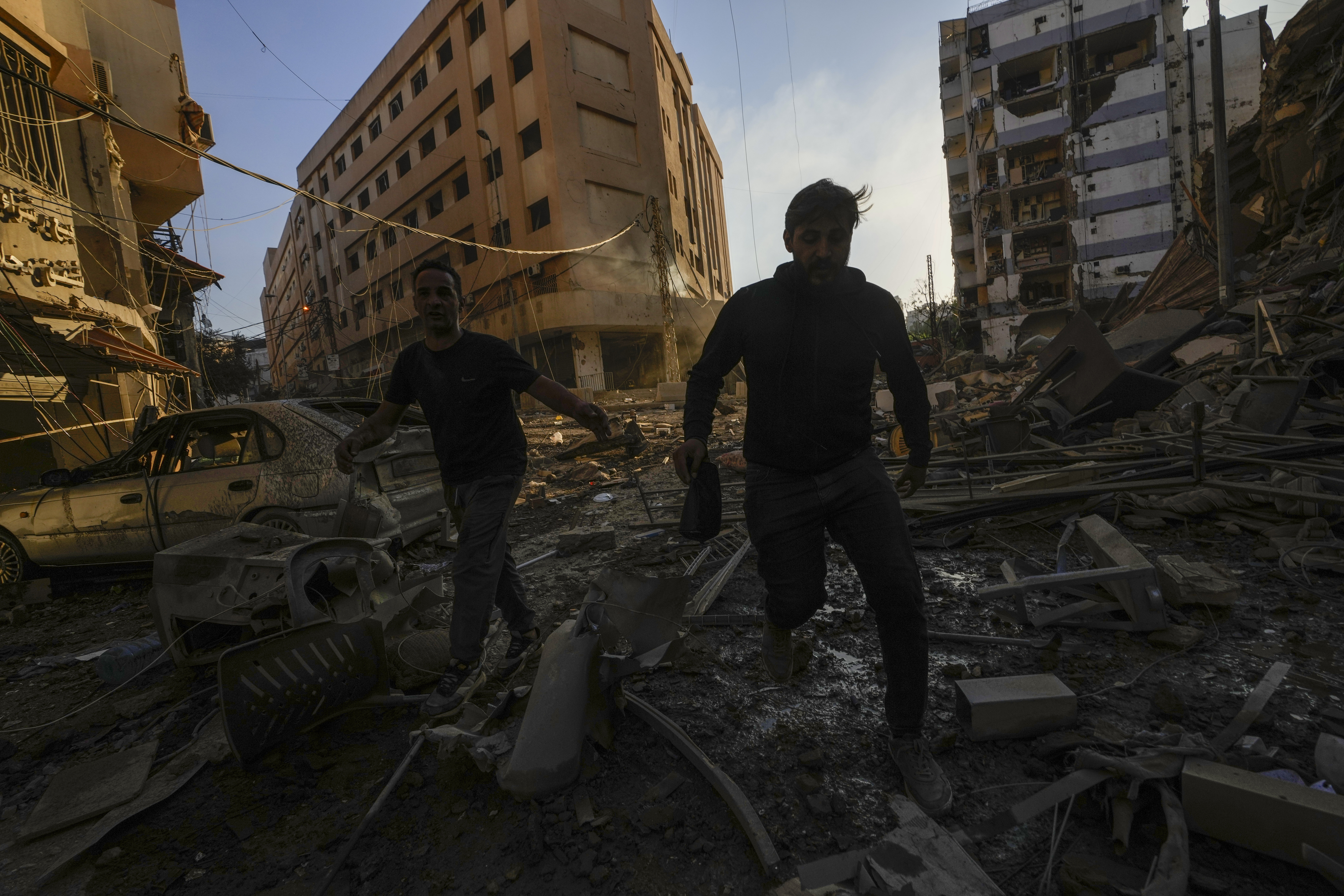 Residents run for cover following an Israeli airstrike in Dahiyeh, Beirut, Lebanon, Friday, Oct. 4