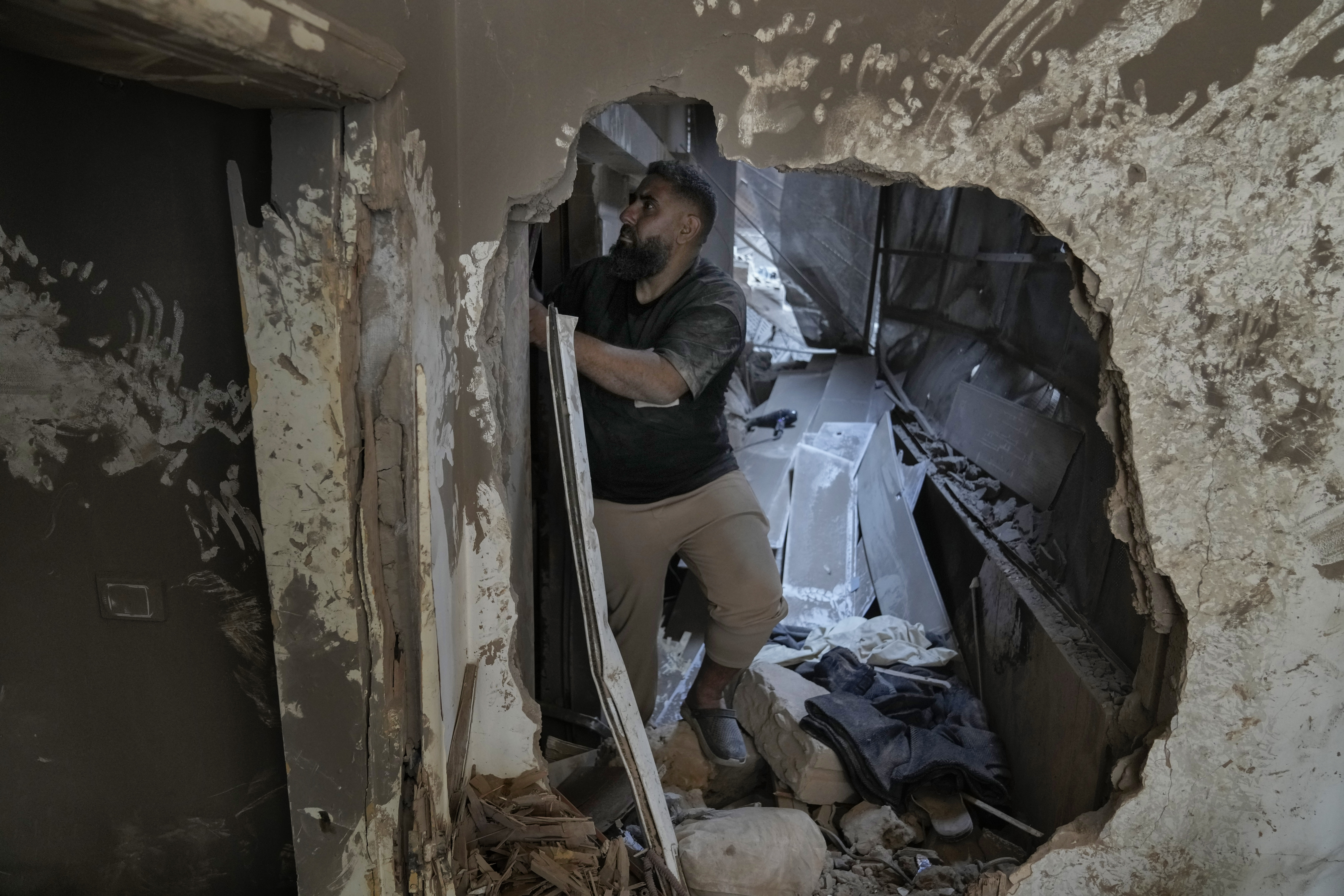 Ahmad al-Khatib stands in his in-laws apartment where he, his wife, Marwa Hamdan, and their 2 and a half-year-old daughter, Ayla, suffered injuries when an Israeli strike destroyed a three-story building next to theirs, in Beirut, Lebanon, Friday, Oct. 11