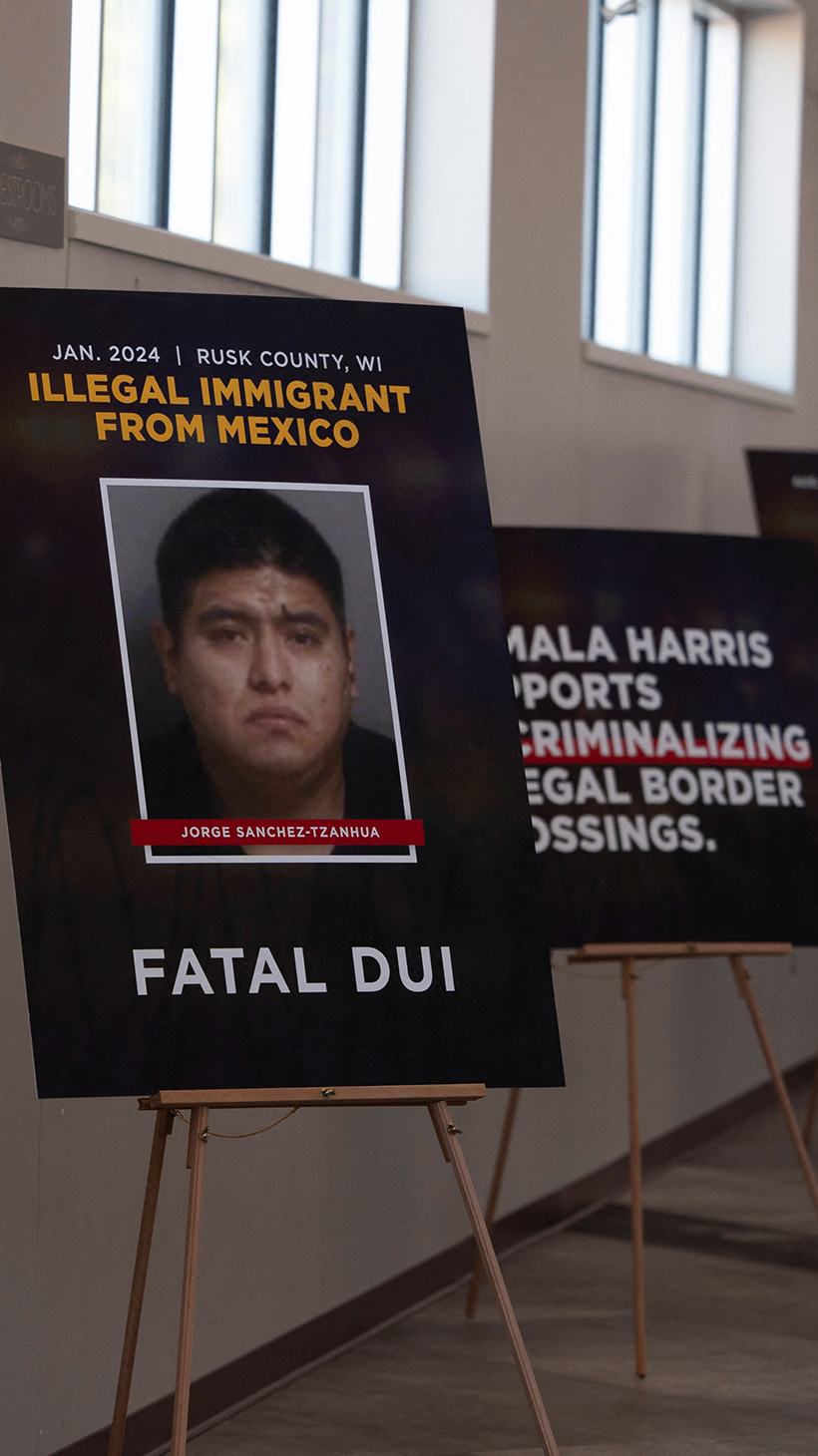 A series of easels shows anti-immigration posters, including one that reads: "End the invasion of small town America."