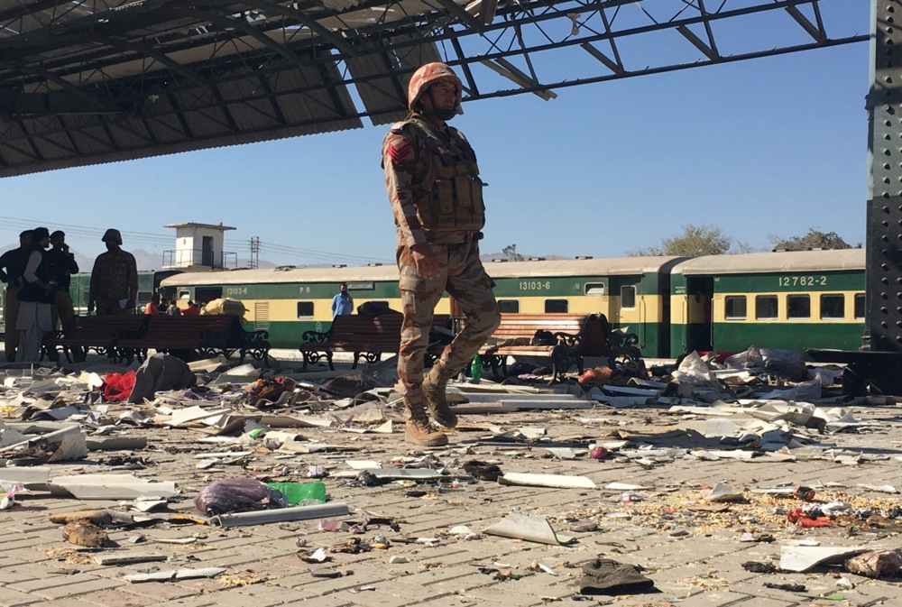 Pakistani security officials inspect the scene of a blast at a railway station in Quetta