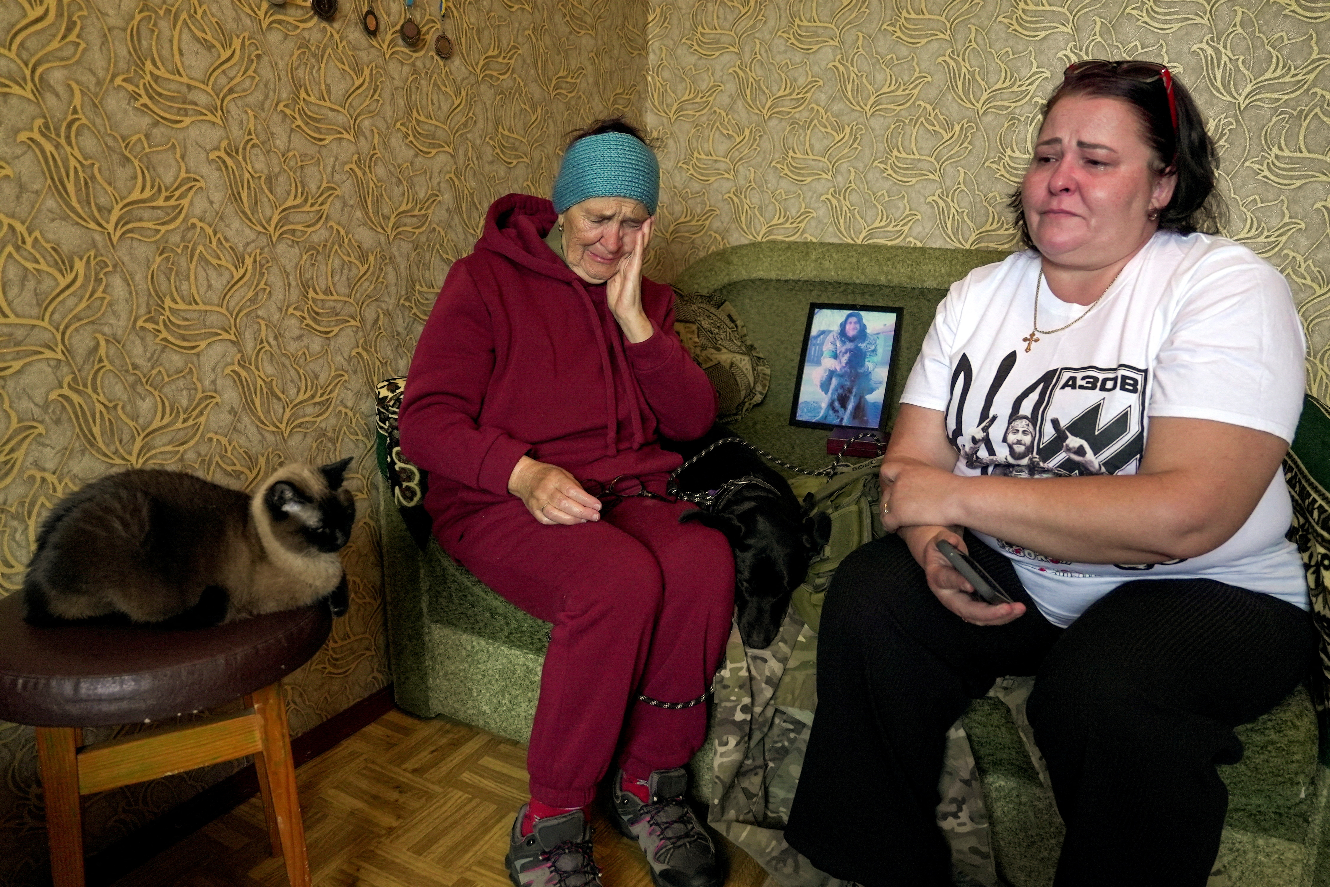 Liudmyla Bordus sits with her mother Tamara in the bedroom of her son, fallen Ukrainian soldier Maksym Bordus,with a picture of Maksym's grandmother Tamara Bordus in the background, amid Russia's attack on Ukraine, in Kyiv, Ukraine,October 18, 2024. REUTERS/Anna Voitenko TPX IMAGES OF THE DAY