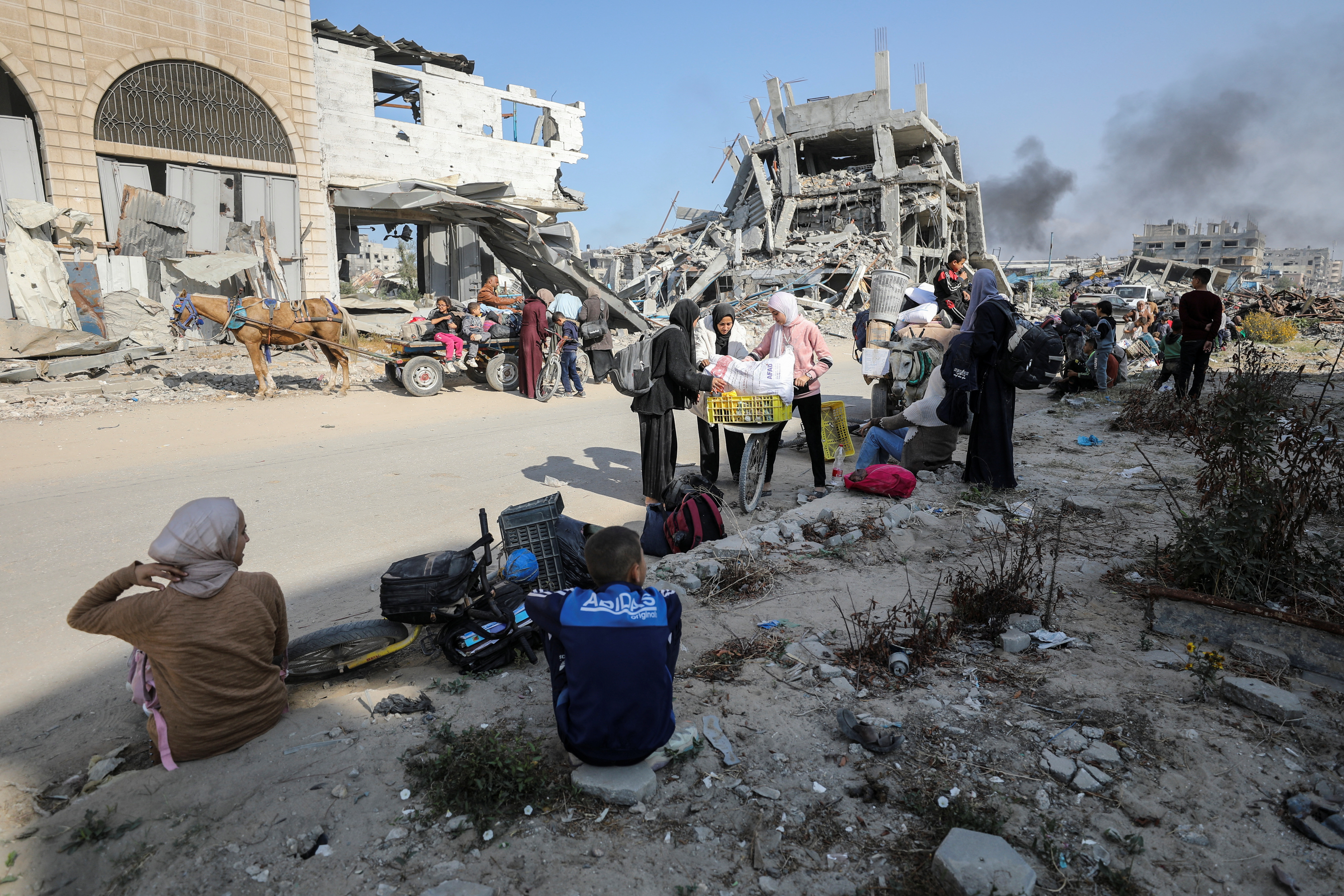 Displaced Palestinians make their way after fleeing the northern part of Gaza
