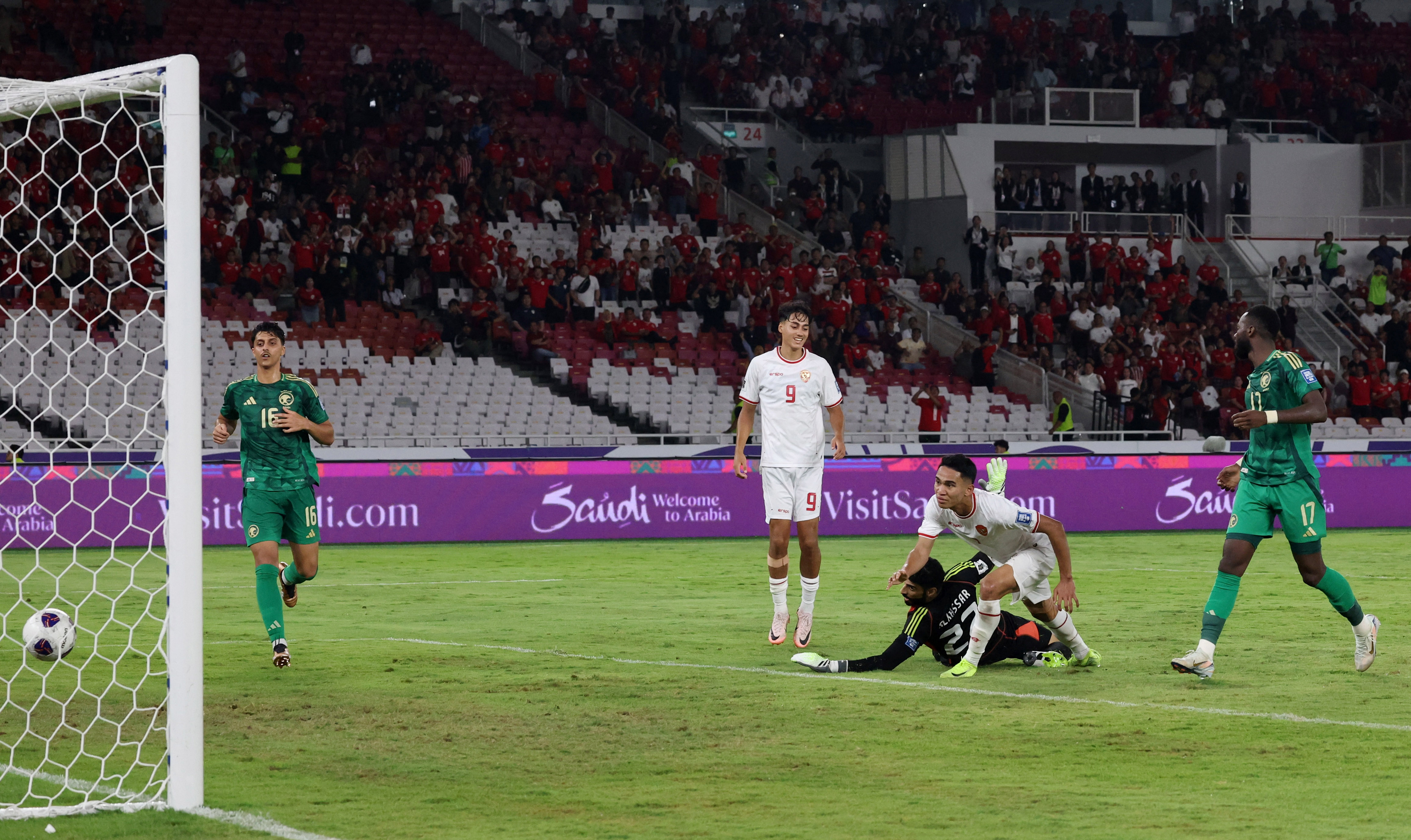 Soccer Football - World Cup - Asian Qualifiers - Third Round - Group C - Indonesia v Saudi Arabia - Gelora Bung Karno Main Stadium, Jakarta, Indonesia - November 19, 2024 Indonesia's Marselino Ferdinan scores their second goal as Saudi Arabia's Ahmed Al Kassar looks on REUTERS/Ajeng Dinar Ulfiana