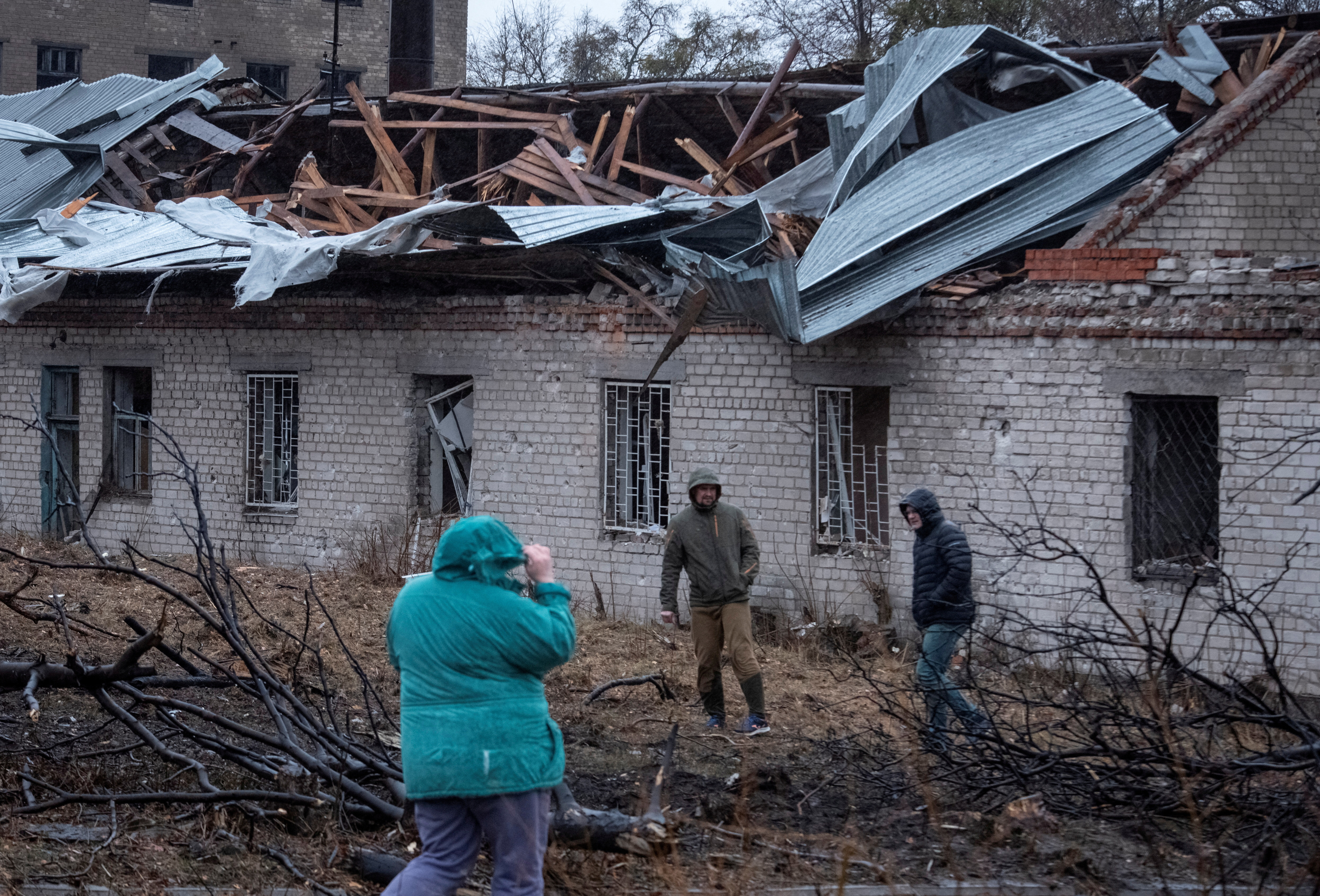 Residents walk at a site of a Russian missile strike, amid Russia's attack on Ukraine, in Dnipro,