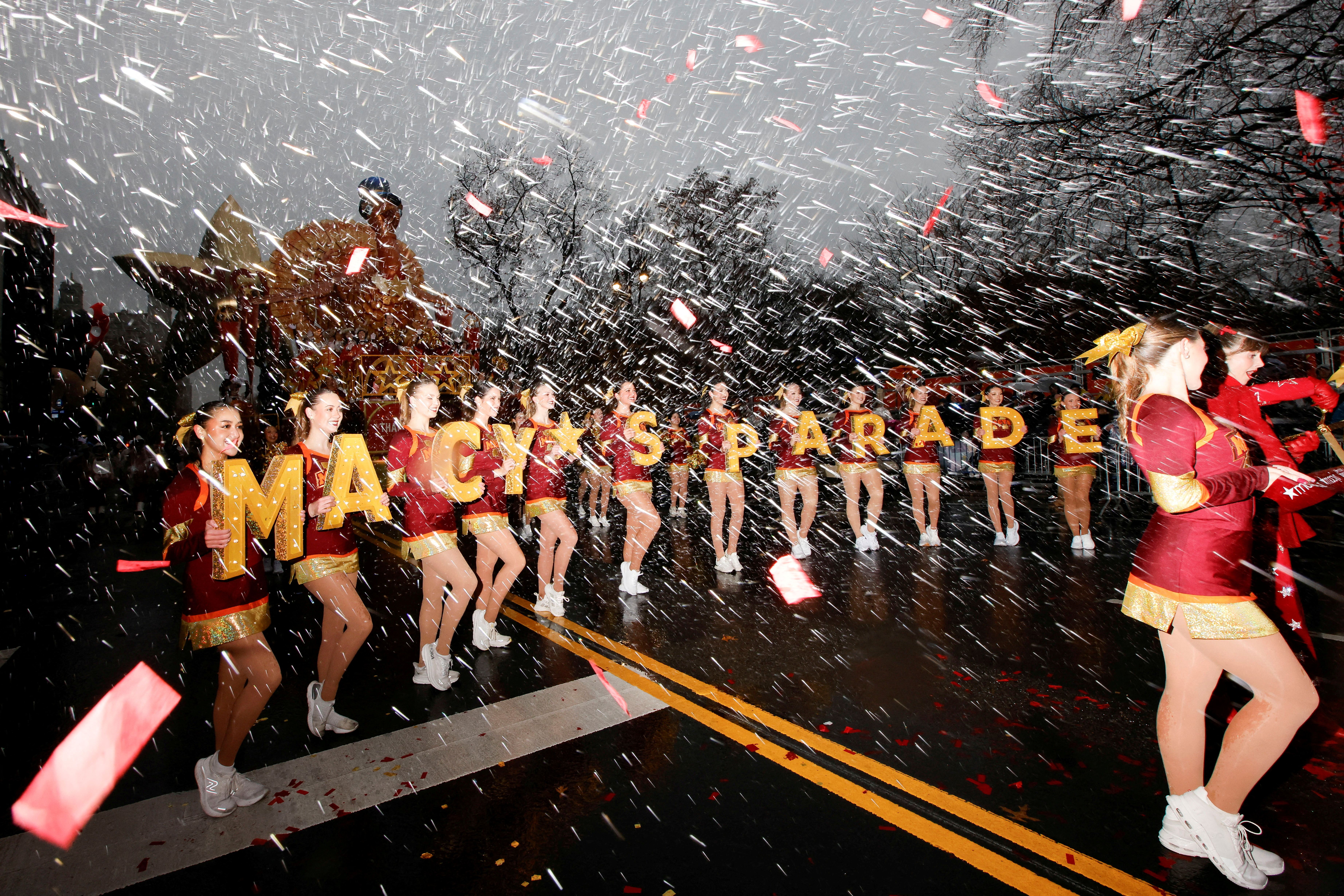 A marching band walks through pouring rain.