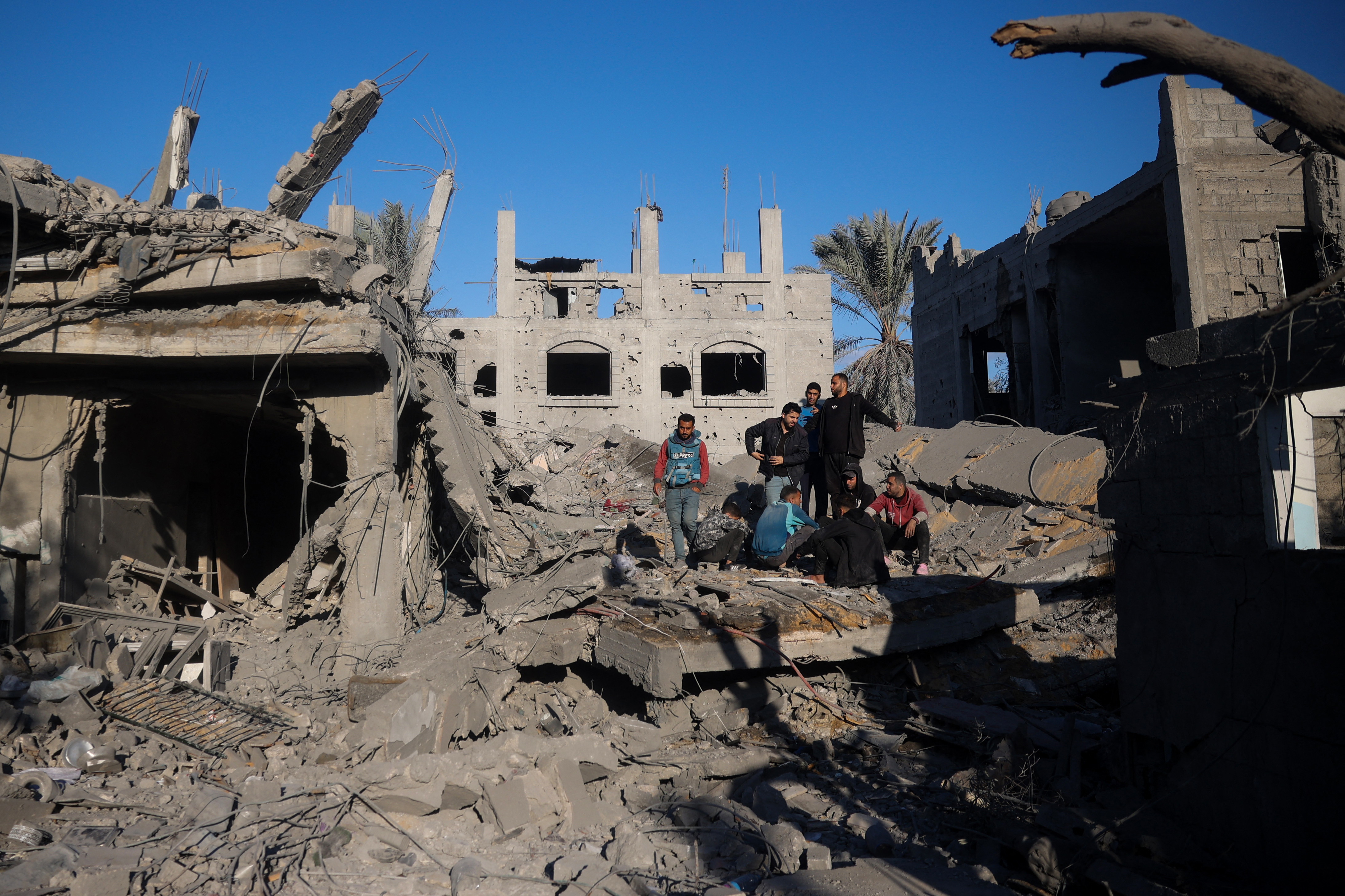 Palestinians gather on the rubble of a house destroyed in an Israeli strike at the Nuseirat refugee camp, central Gaza Strip