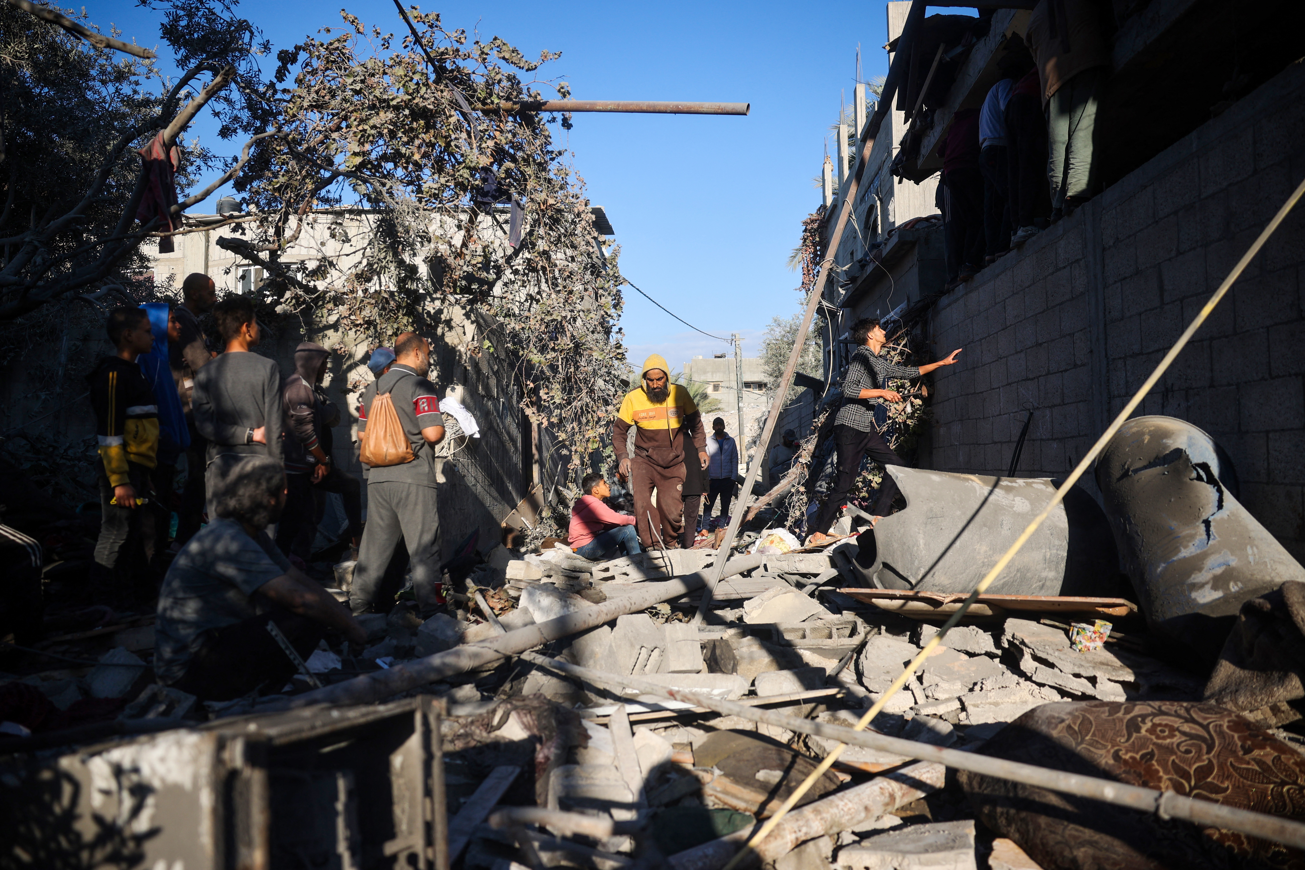 Palestinians gather outside a house destroyed in an Israeli strike at the Nuseirat refugee camp, central Gaza Strip