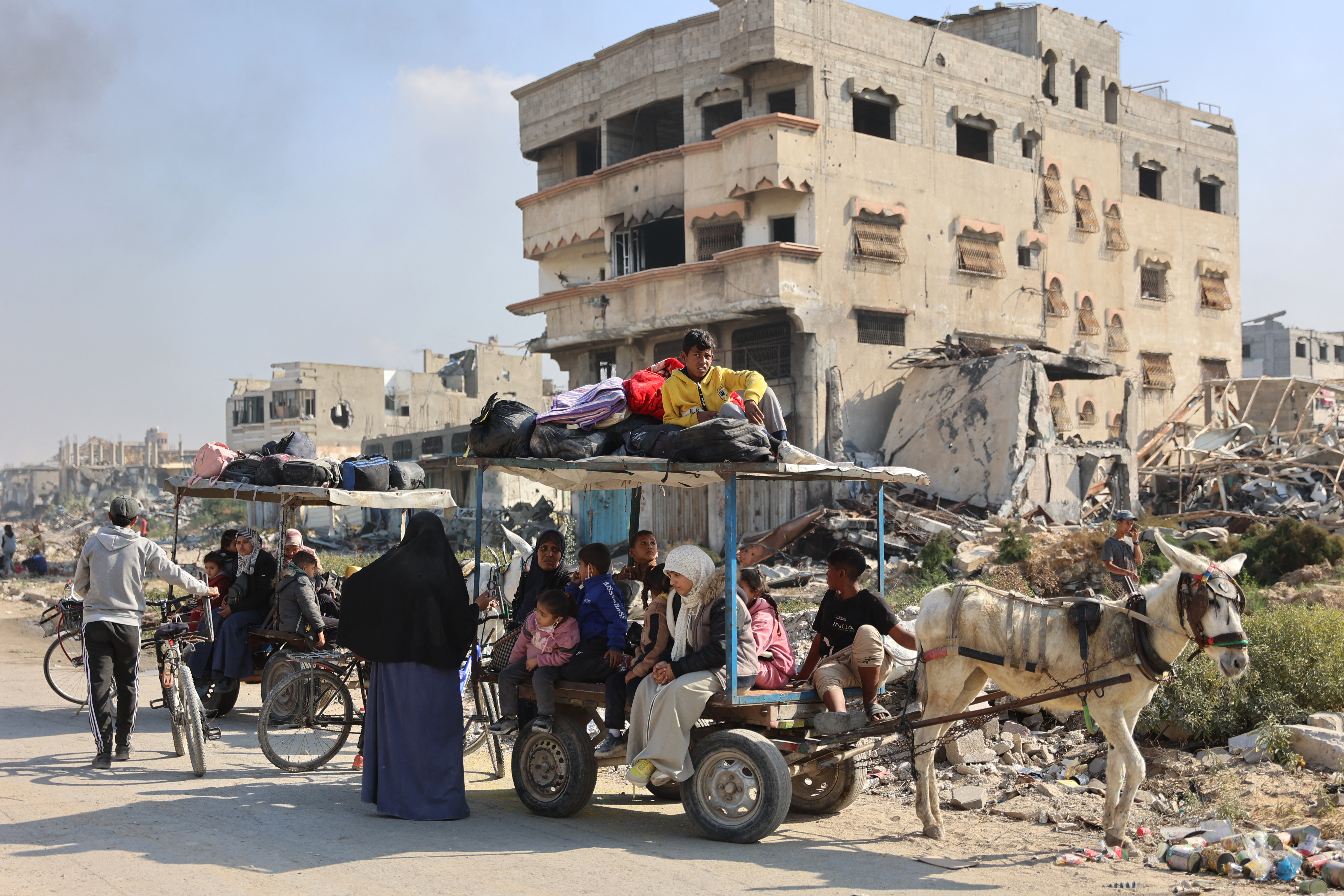 Palestinians displaced from shelters in Beit Hanoun cross the main Salaheddine road into Jabalia in the northern Gaza Strip