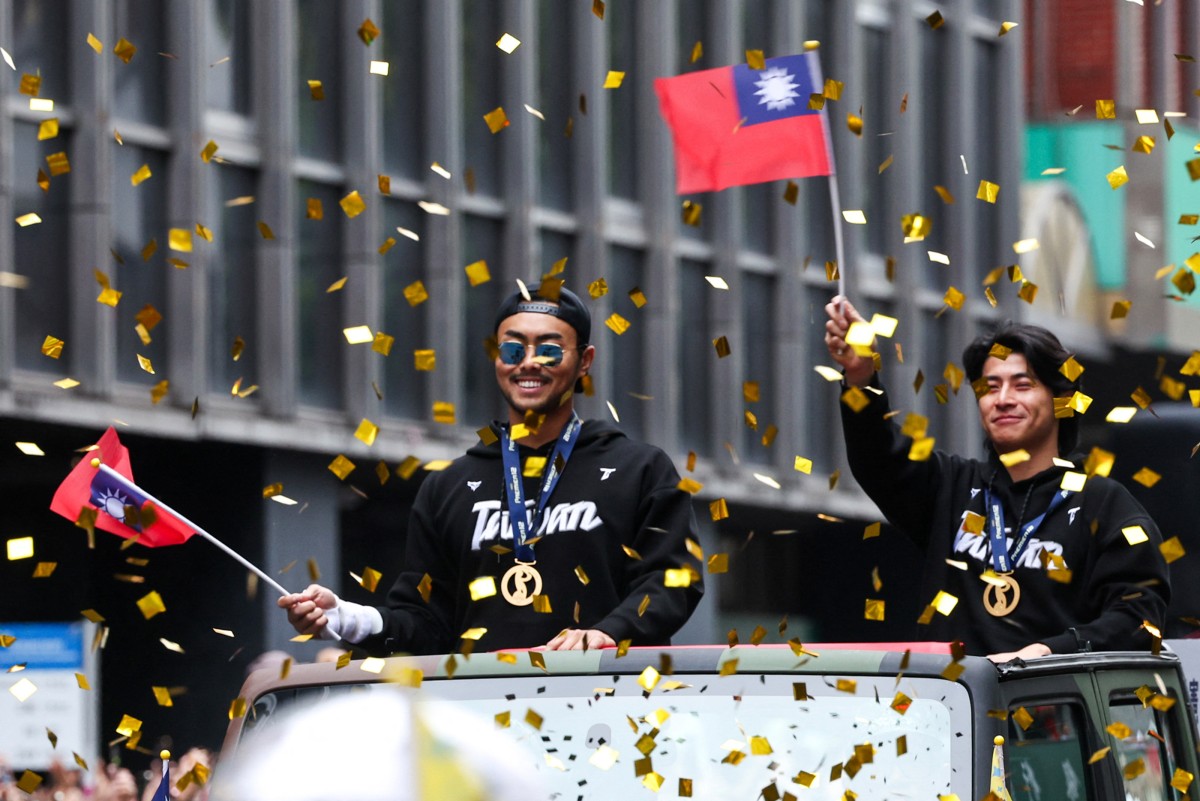People cheer on players of Team Taiwan during a parade held to celebrate winning the WBSC Premier12 2024 baseball tournament, in Taipei