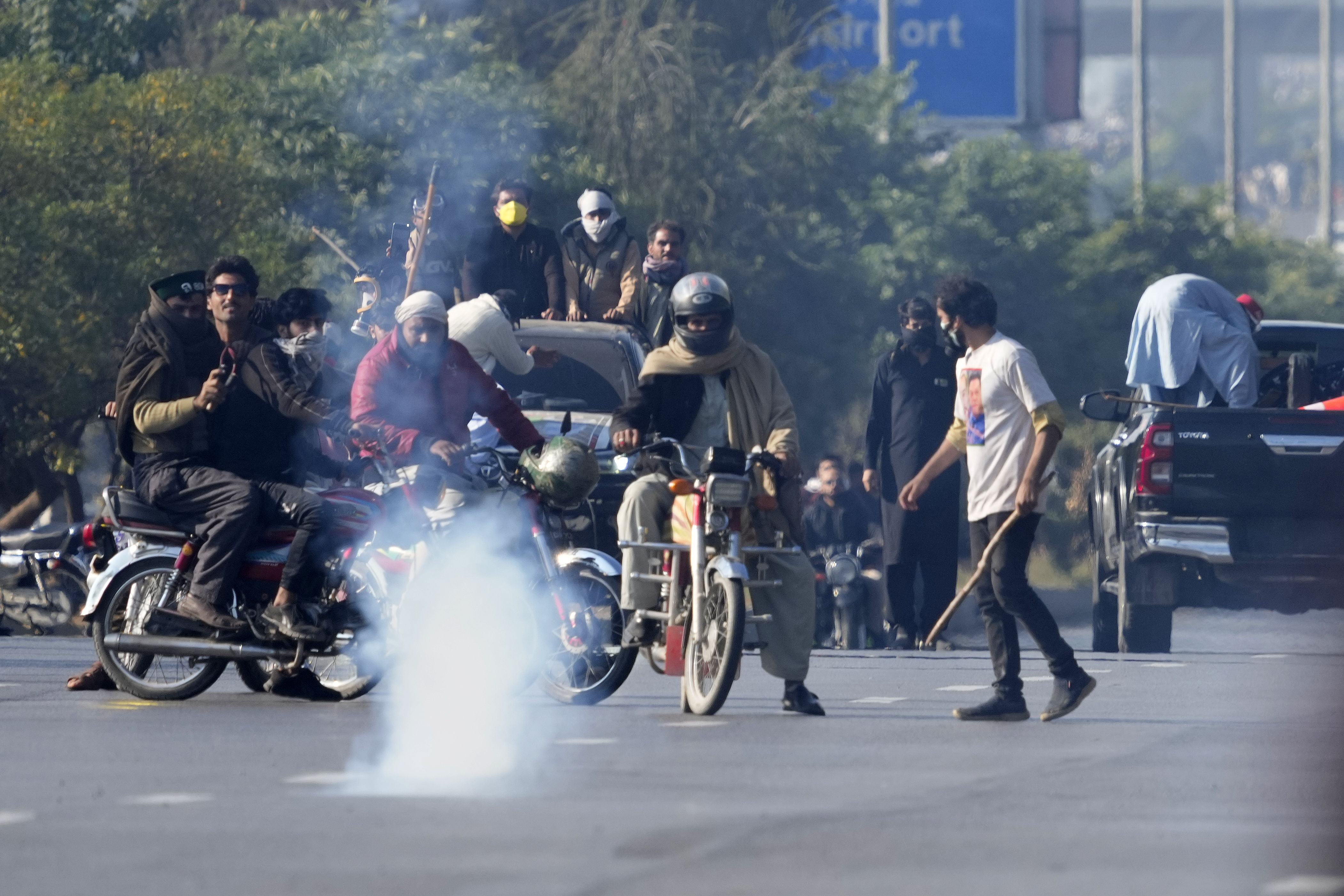PTI supporters advance after police fired tear gas shell to disperse them during clashes, in Islamabad, Pakistan