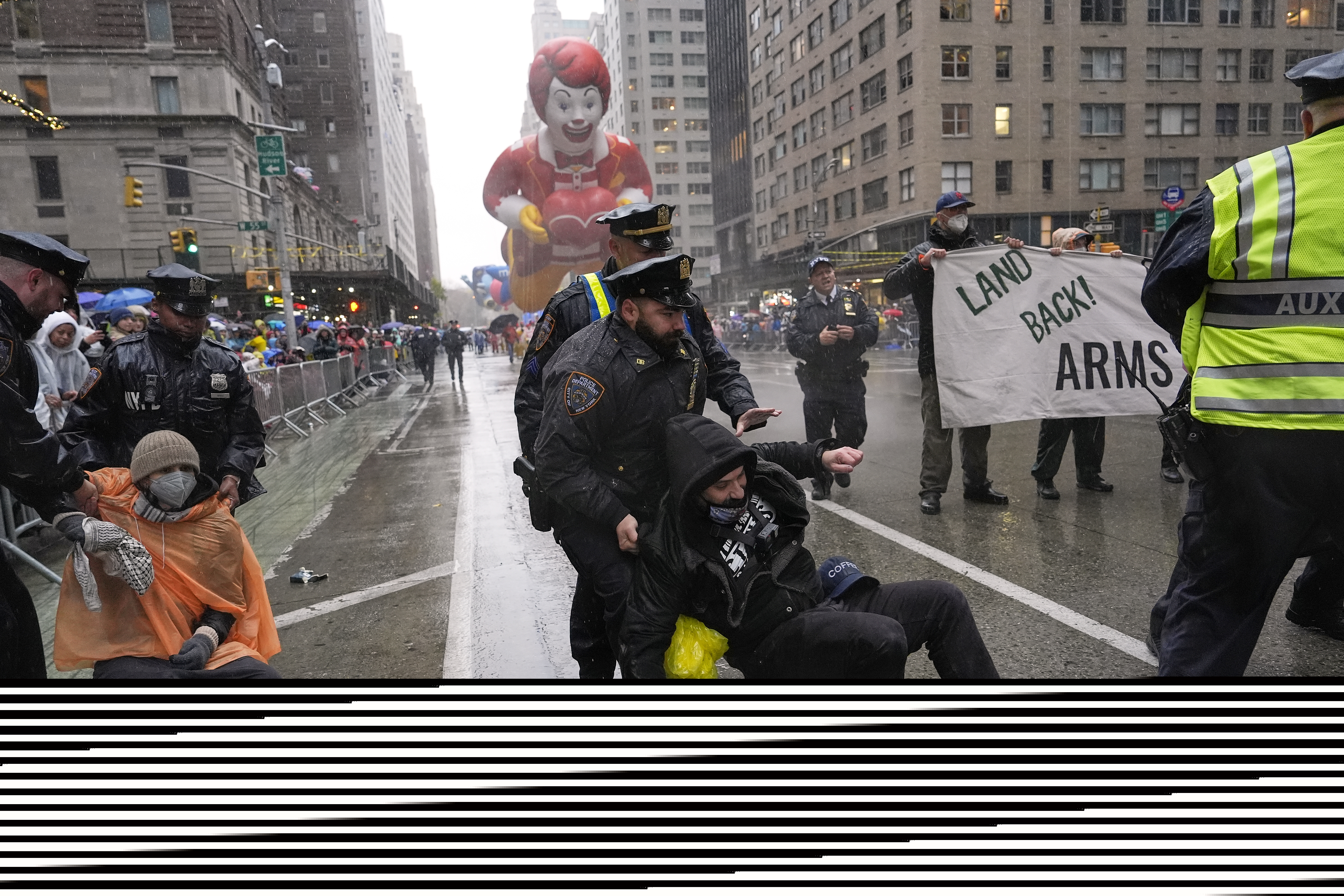 A police officer pulls a protester down on a rainy New York street