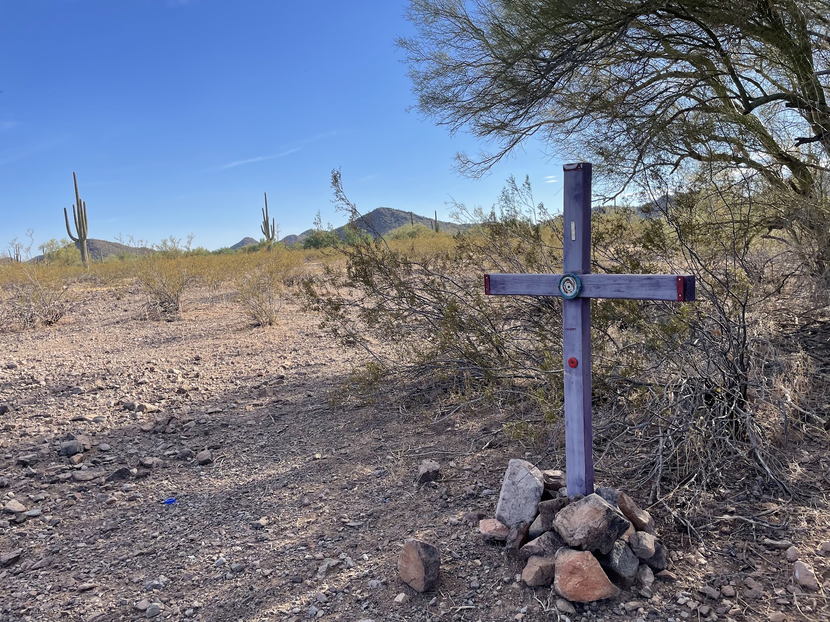 A roughly hewn cross sits in the middle of the Arizona desert.