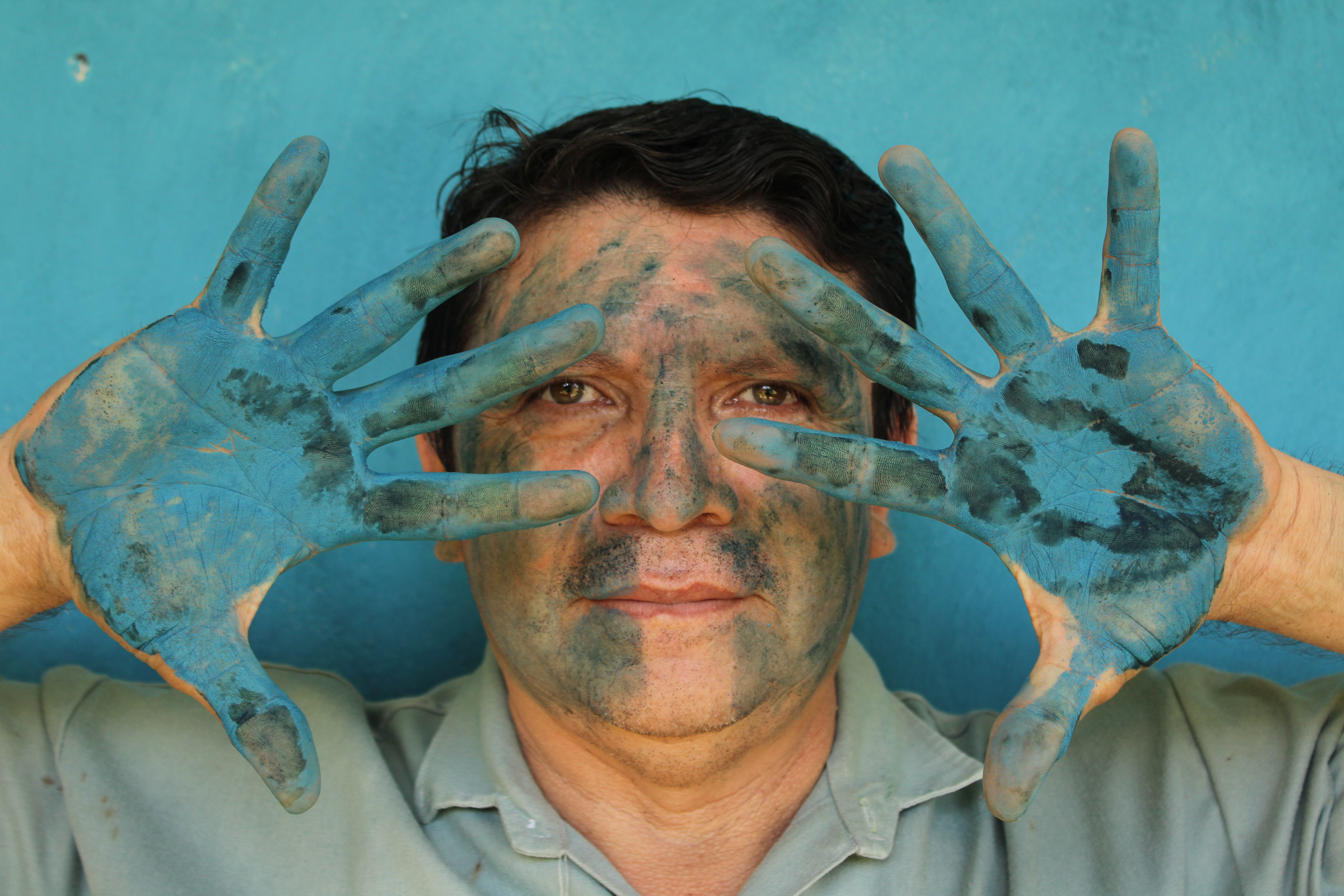 Luis May Ku, 49, poses with his hands painted in Maya Blue outside his home in Dzan, Yucatán, Mexico, on 9 September, 2024
